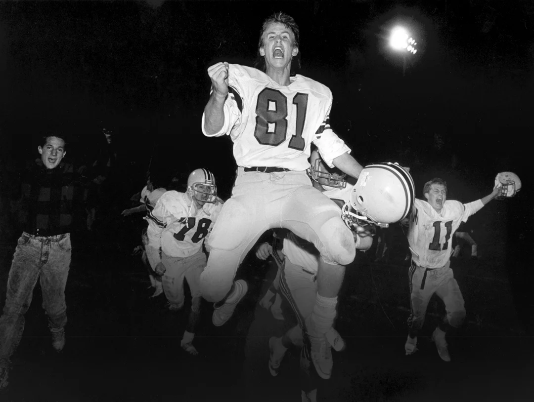 Members of the Algona Garrigan football team celebrate after defeating a heated rival in a playoff game. This image won Best of Show in the 1987 Iowa Press Association contest; the entire portfolio won Photographer of the Year / Small Markets.