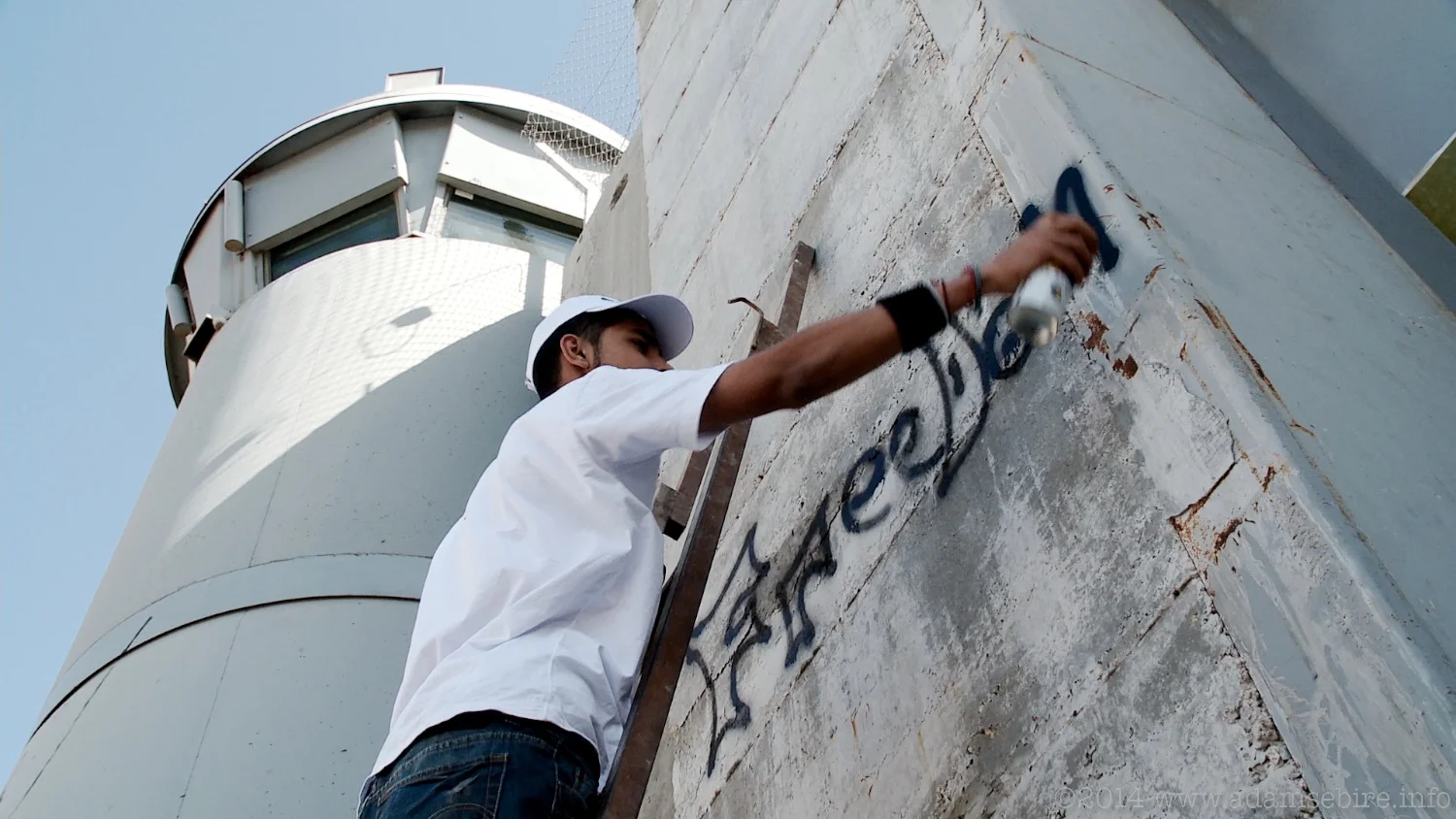 Painting graffiti on the Israeli separation barrier at Bethlehem