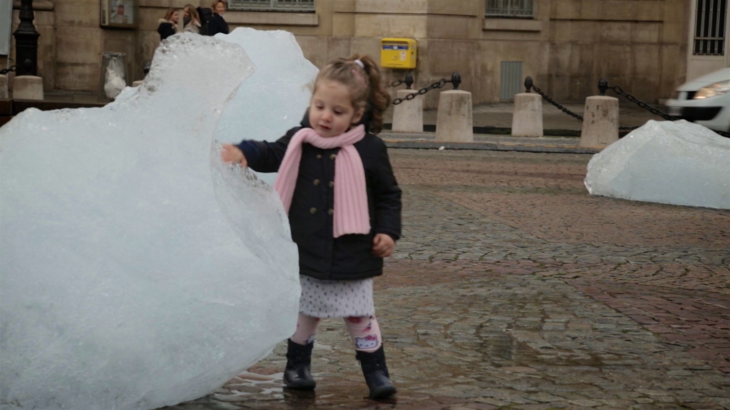 Girl touches melting ice from Arctic glacier at COP21 Paris.jpg