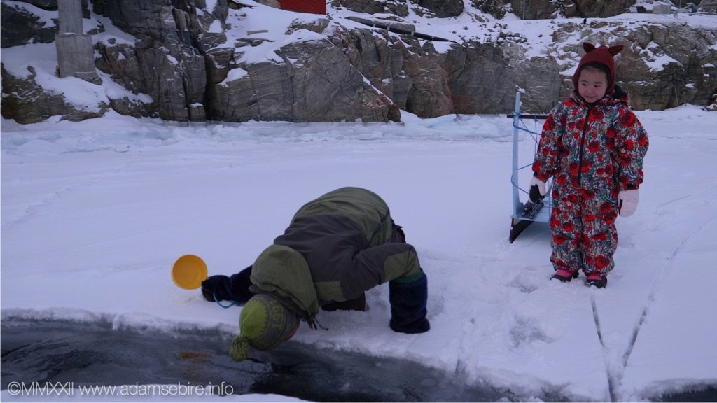 Greenland - Inuit father checking the sea ice thickness.jpg