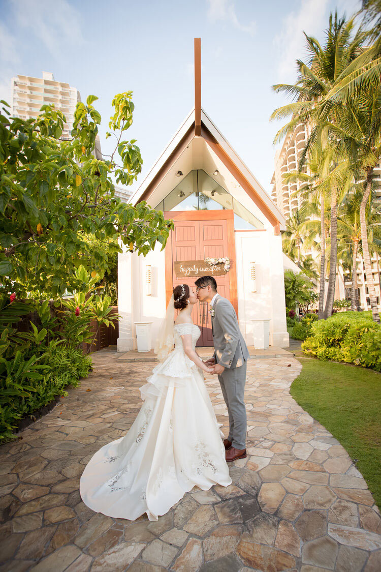 bride-and-groom-kissiing-outside-white-beach-chapel-doors.jpg