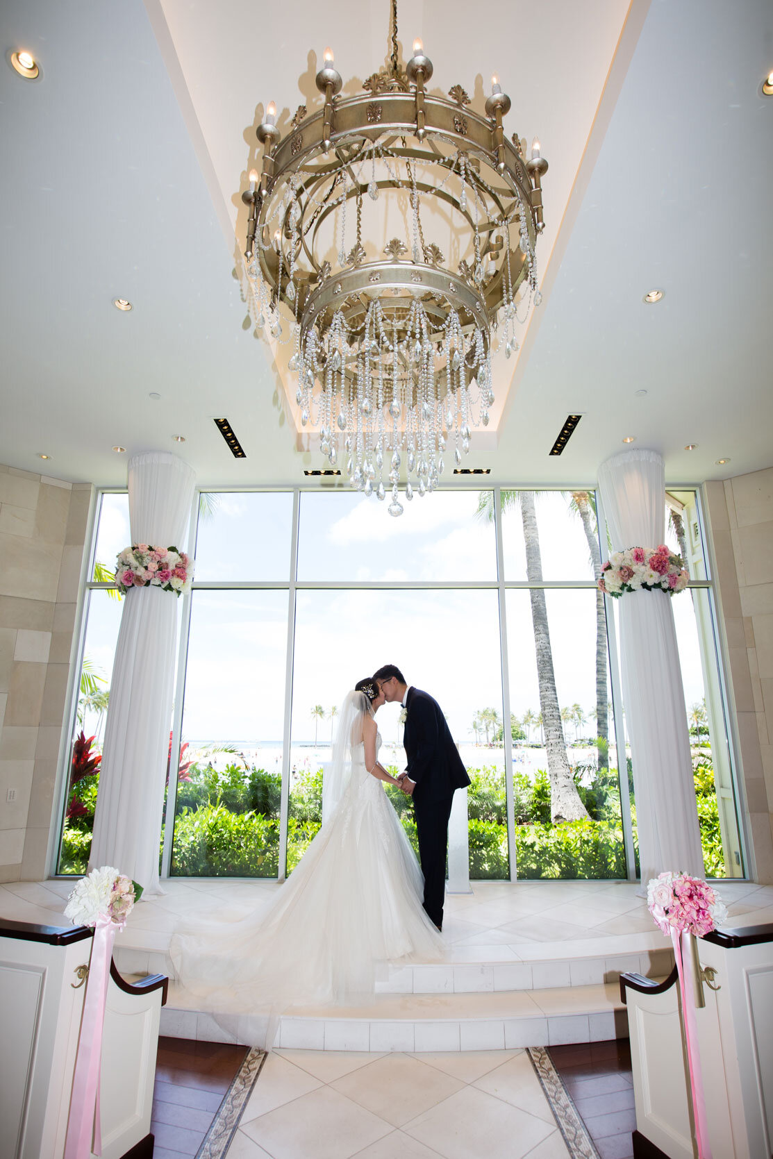 couple-kissing-at-altar-white-beach-chapel-waikiki-wedding-venue.jpg