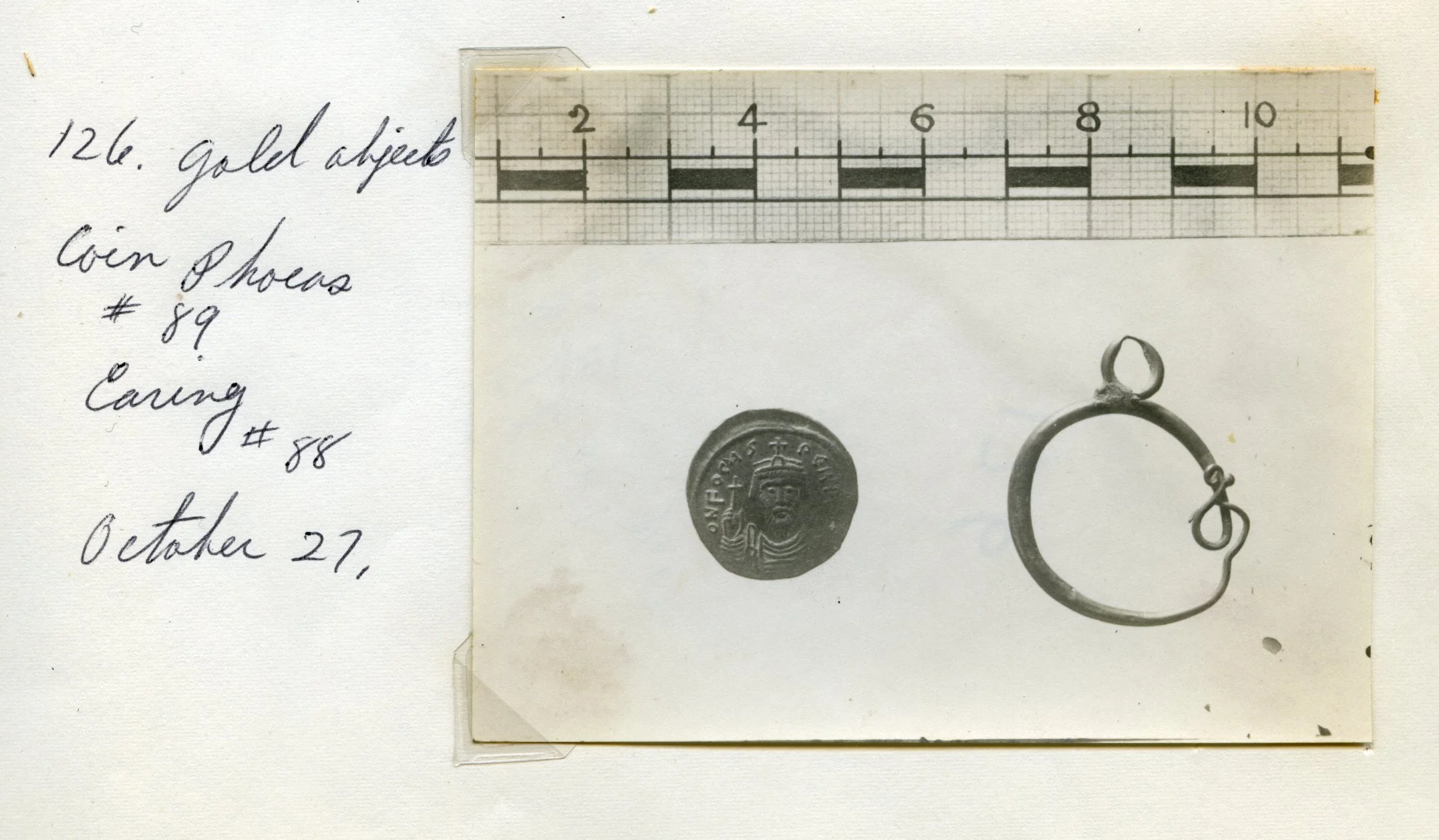 Coin of Emperor Phocas (602-610) found in House III on the tell. Photographed in 1921, alongside a gold earring now found in the University of Pennsylvania collection. The coin is kept at the Rockefeller Museum, Jerusalem.