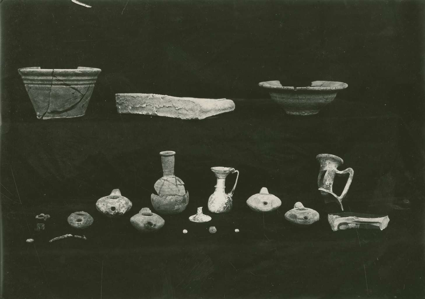 Photograph of the objects, including the jug located at the center, found in Tomb 207