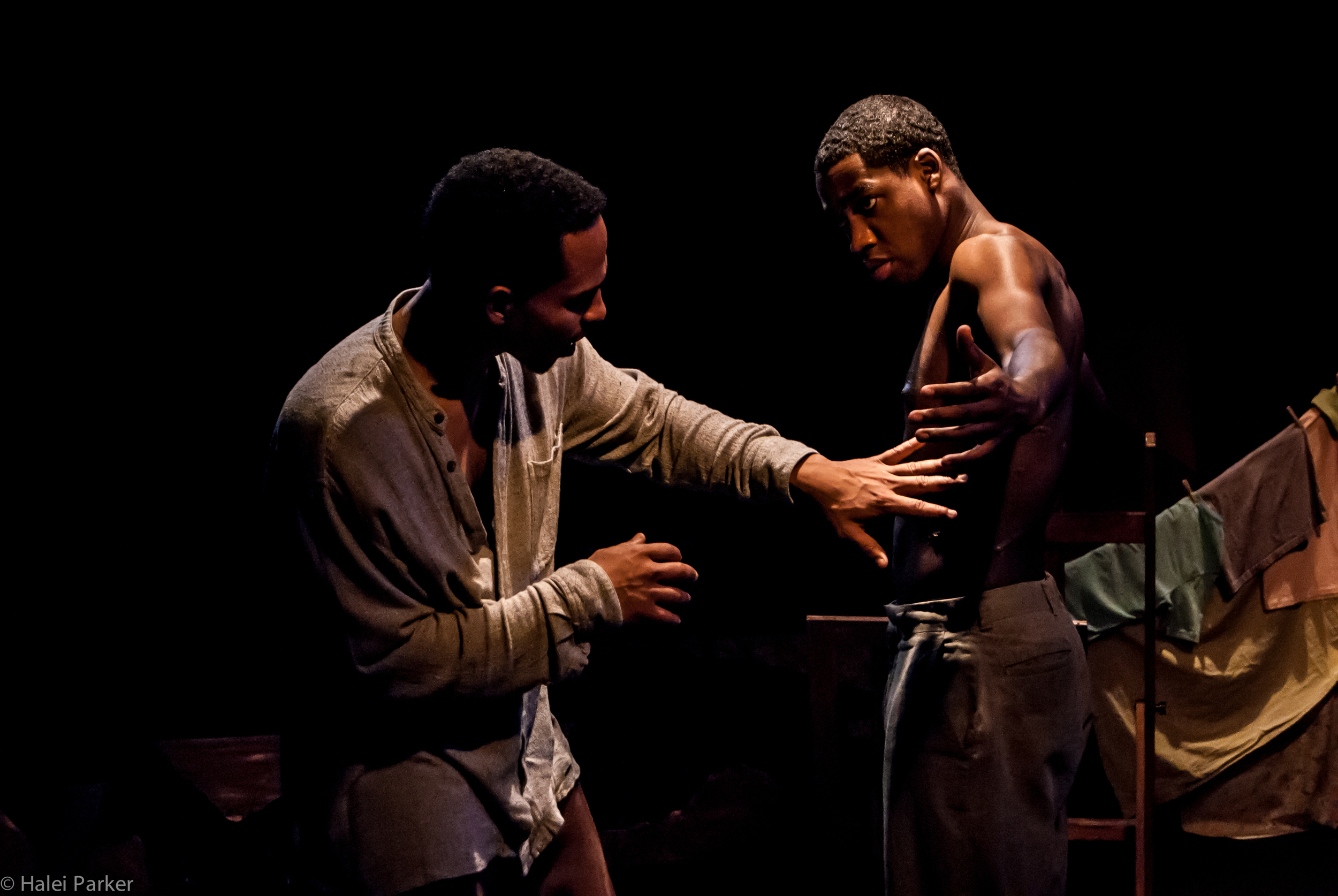 Edwin (Gerard Joseph) touches the scars that Henri-Max (Maurice Williams) got while being tortured by Duvalier's boogiemen.