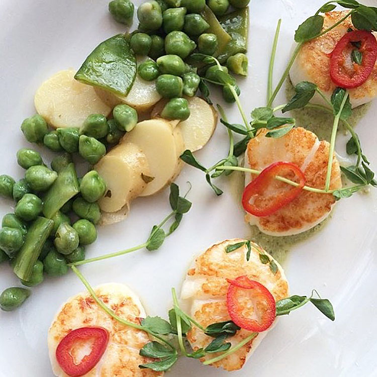 Seared Montauk sea scallops with fingerling potatoes, green chick peas, corrander crema and pickled fresno chilies