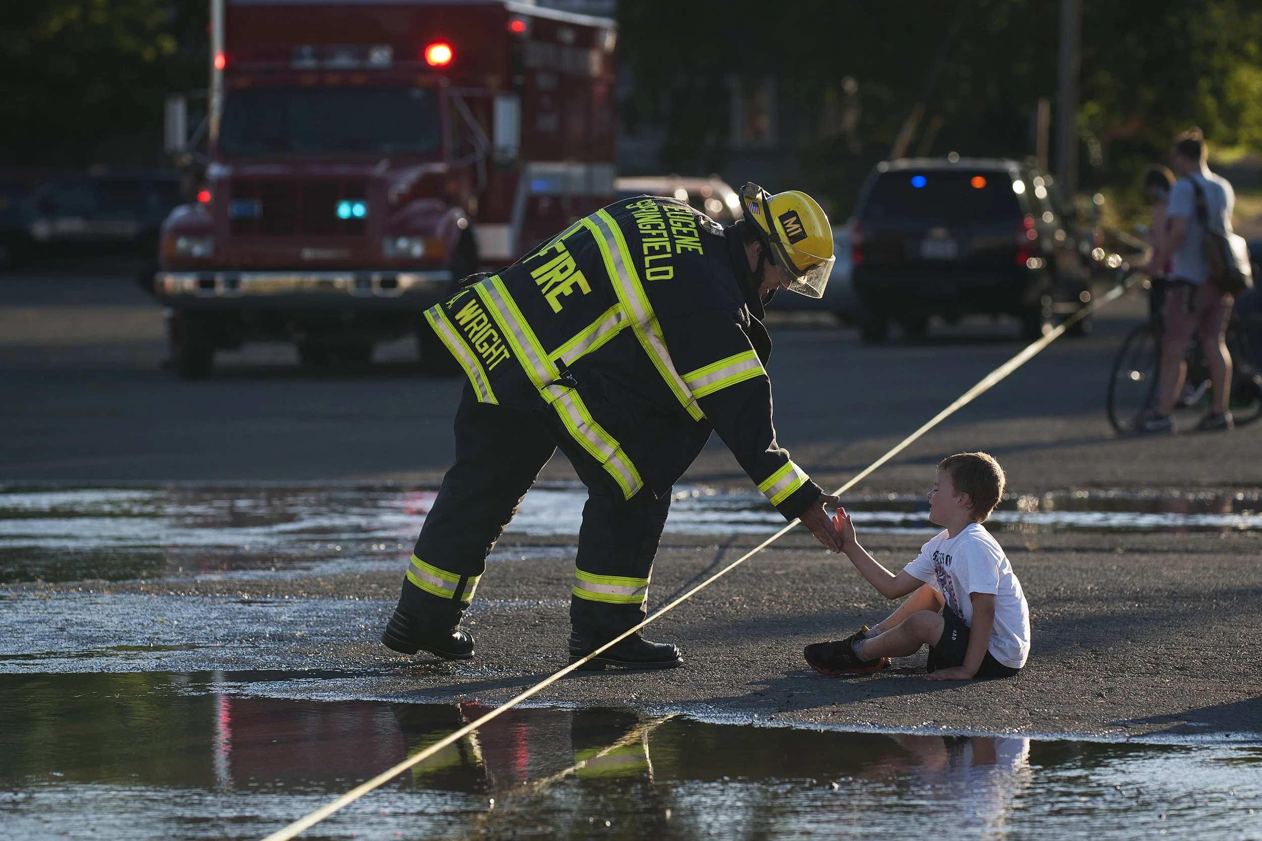  Firefighter Aaron Wright high-fives Braxton Maples, 5, as Eugene and Springfield fire departments worked to extinguished a structural fire that destroyed Civic Stadium on Monday. 