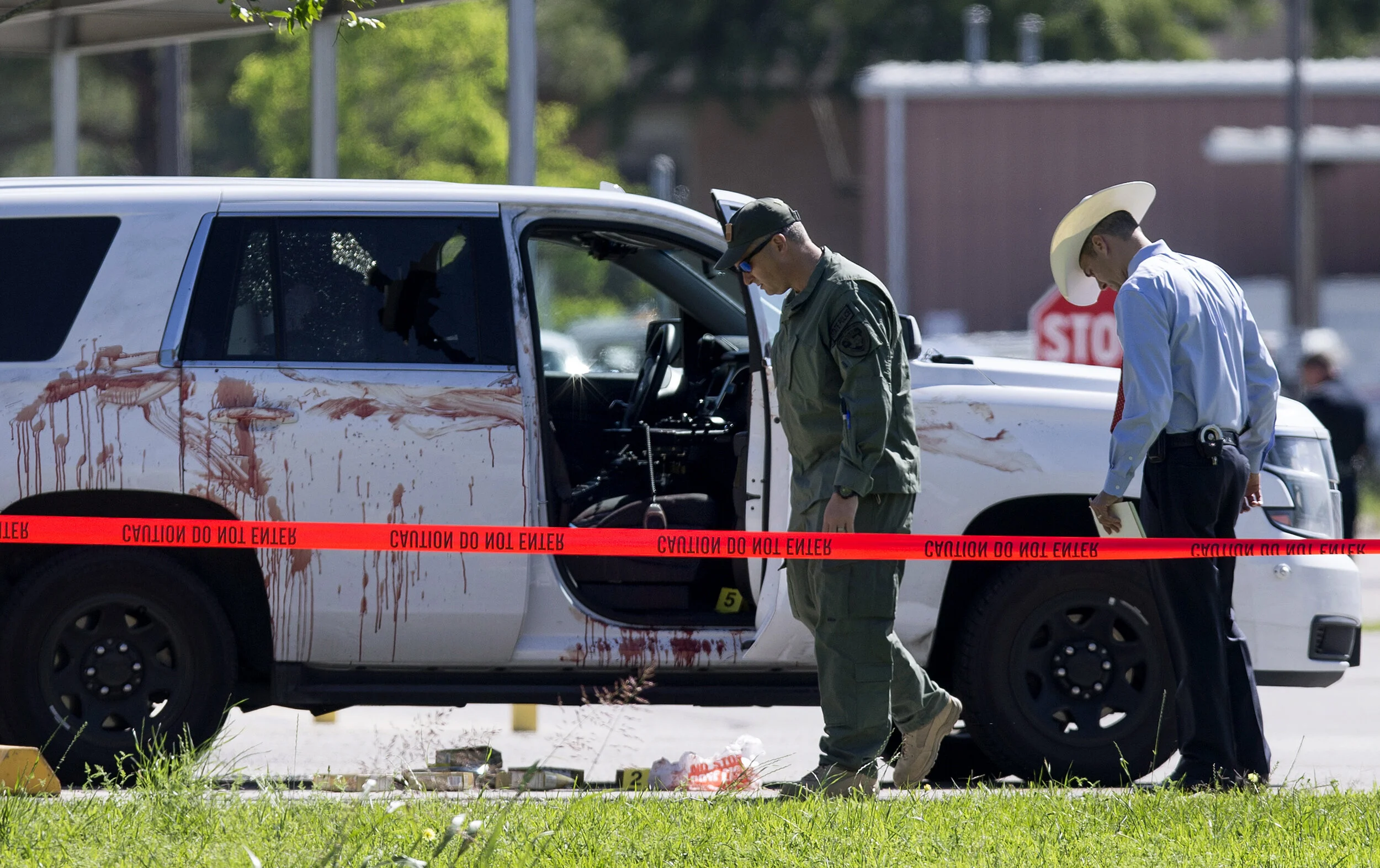  Authorities investigate the scene where Precinct 3 assistant deputy chief Clint Greenwood was ambushed and fatally shot as he arrived for work the Baytown Courthouse Monday, April 3, 2017, in Baytown, Texas.  