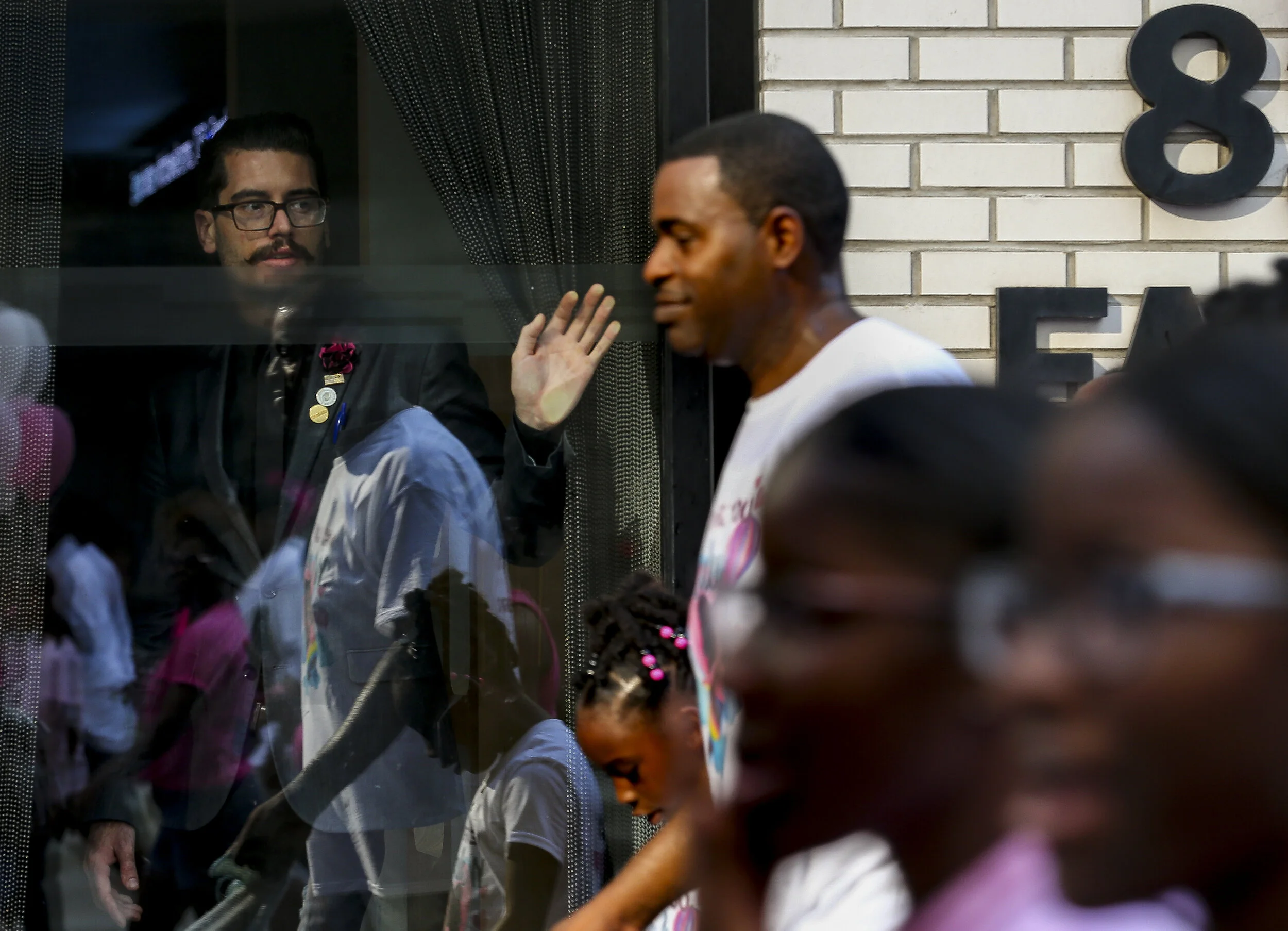  A man looks out of a building as thousands of people marched from City Hall to the Harris County Jail in honor of Maleah Davis, the four-year-old who went missing in early May and whose body was found tossed along an Arkansas freeway last week, on S