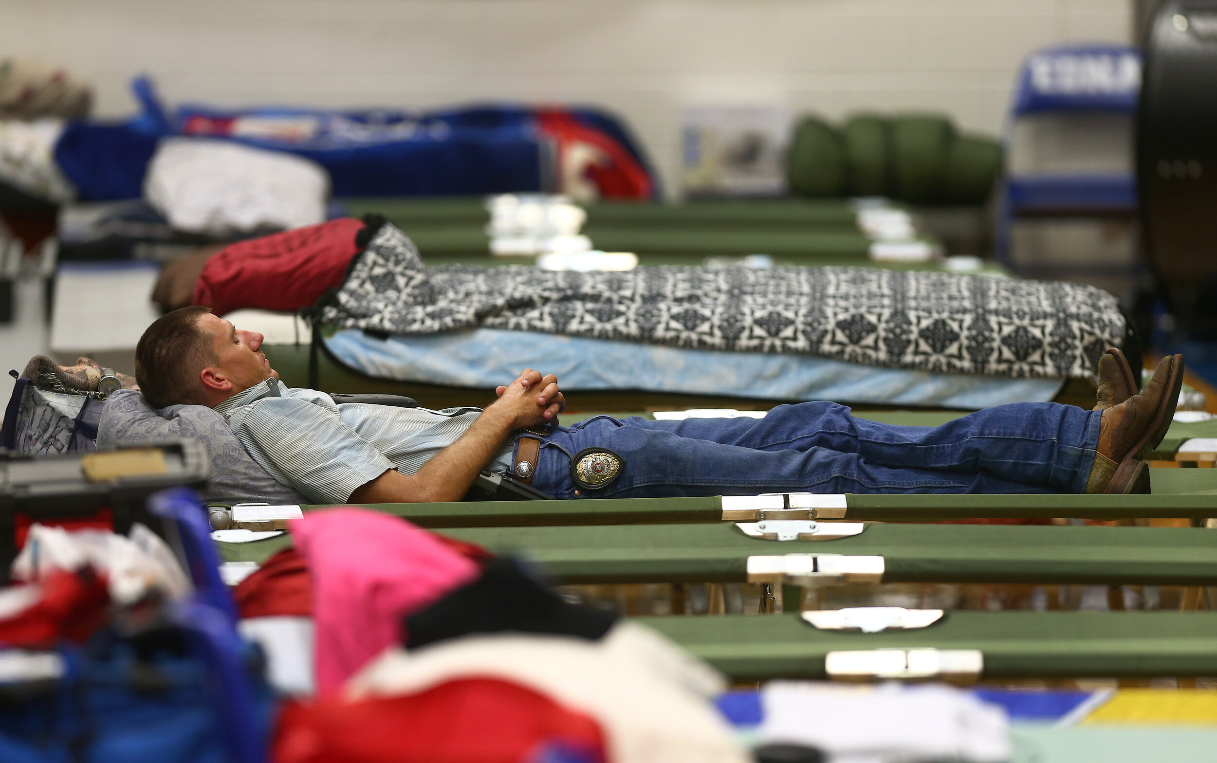  Edna Police patrolman Robert Chastain takes a nap inside the Edna High School Gymnasium, where Jackson County first responders took shelter, as Hurricane Harvey made landfall Friday, Aug. 25, 2017, in Edna, Texas.  Chastain said he had not slept in 