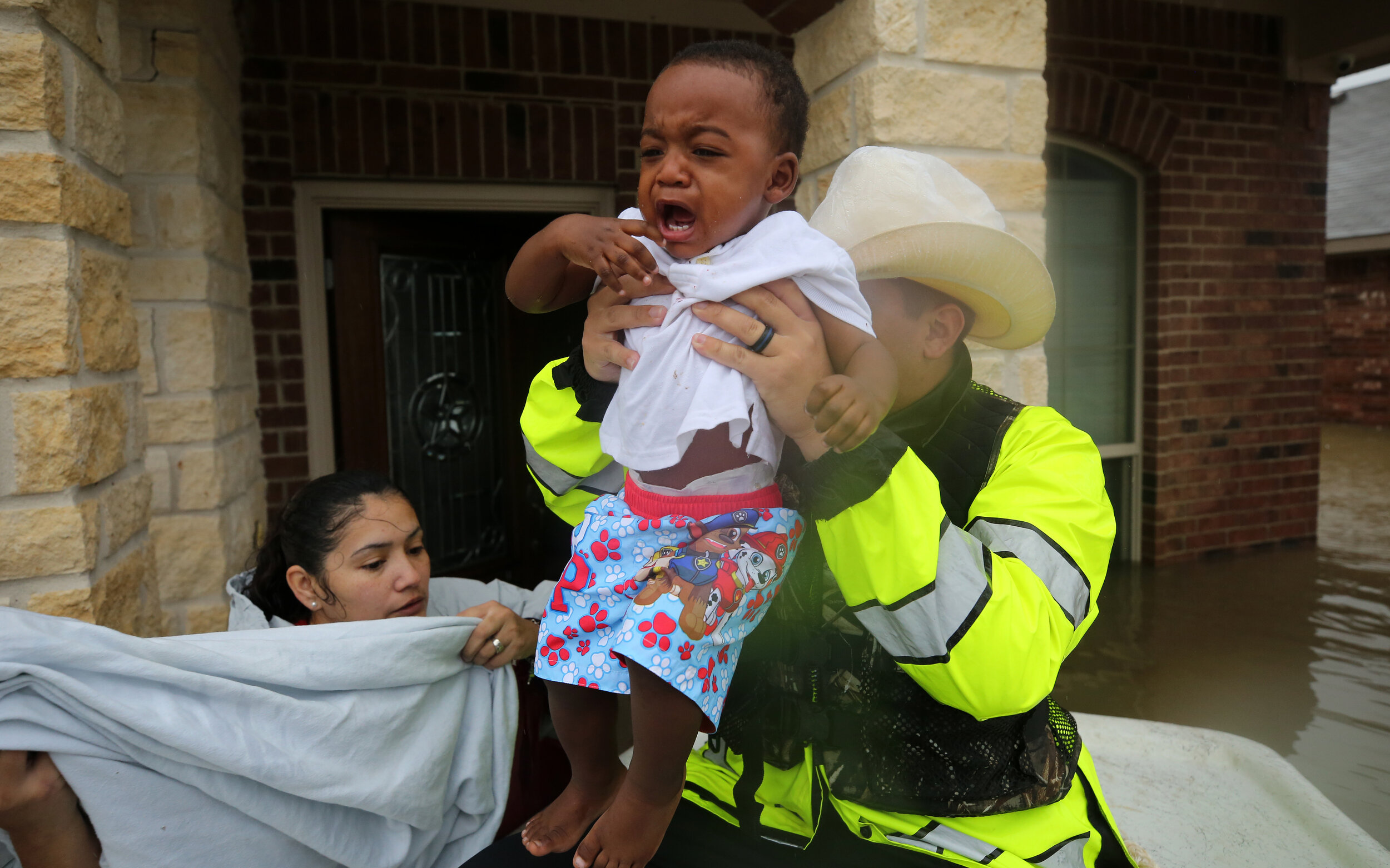  Linda Gonzalez, left, hands one-year-old Joshua Bukes Jr. to Harris County Constable deputy Zach Ryan as they rescued people from flooded homes near Aldine Westfield Road during Hurricane Harvey Monday, Aug. 28, 2017, in Humble, Texas.  