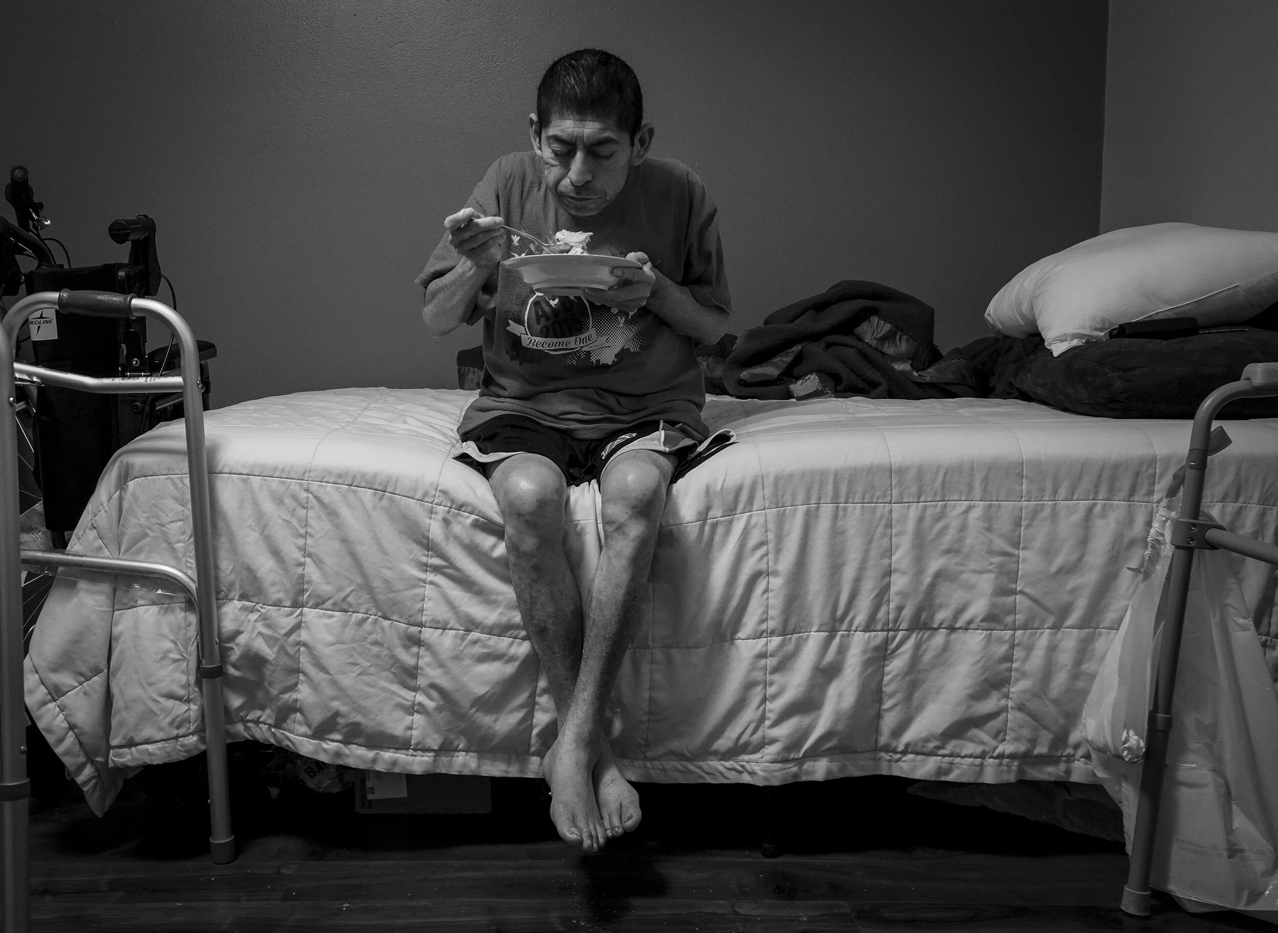  Guillermo Argueta, 53, sits in his bed and eats the scrabbled eggs her daughter made for him.  