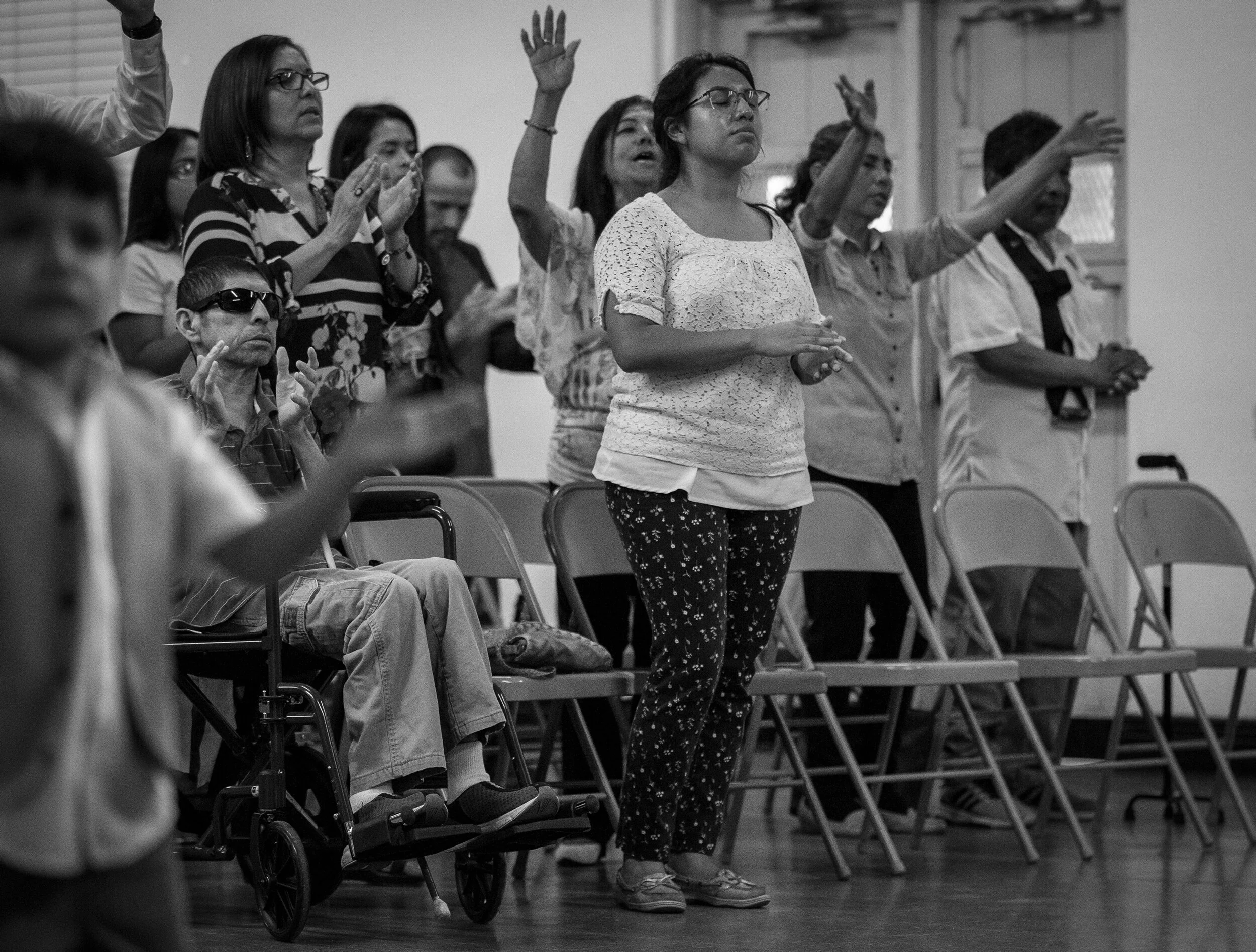  Lorena, center, and Guillermo, pray while attending church service in southeast Houston Friday night. Lorena said she has a hard time having a social life since she now spends her Friday nights taking her father to church and looking after him.  