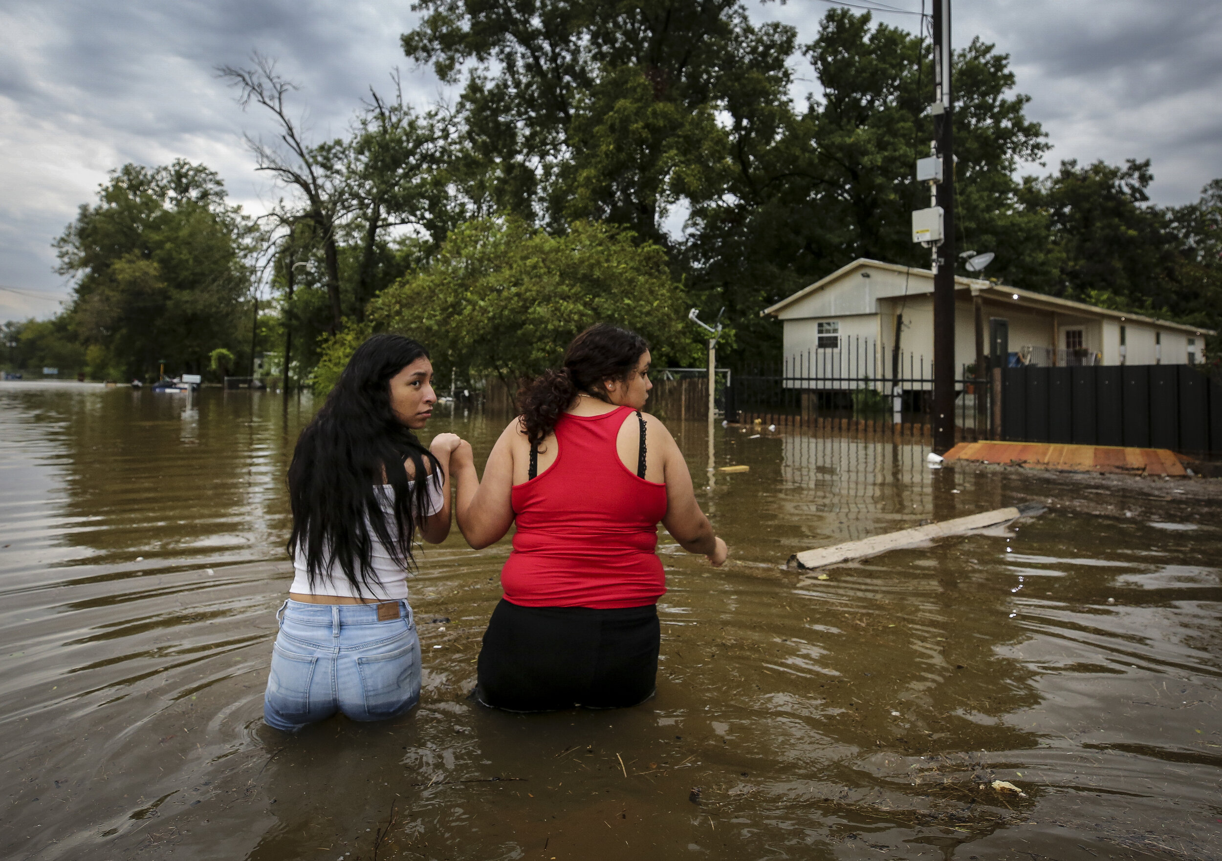  Two women major their way through a flooded street Thursday, Sept. 19, 2019, in Houston, Texas. Tropical Storm Imelda brought heavy rain to the greater Houston area. 