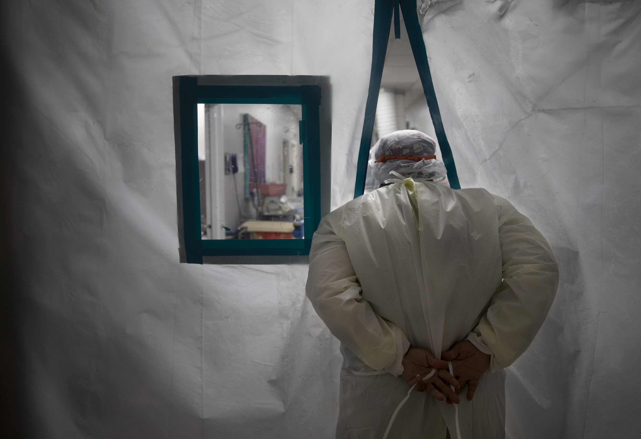  A nurse ties the outermost layer of PPE as she enters a negative pressure wing where patients are kept, inside the COVID-19 intensive care unit at United Memorial Medical Center on Wednesday, July 1, 2020, in Houston.  