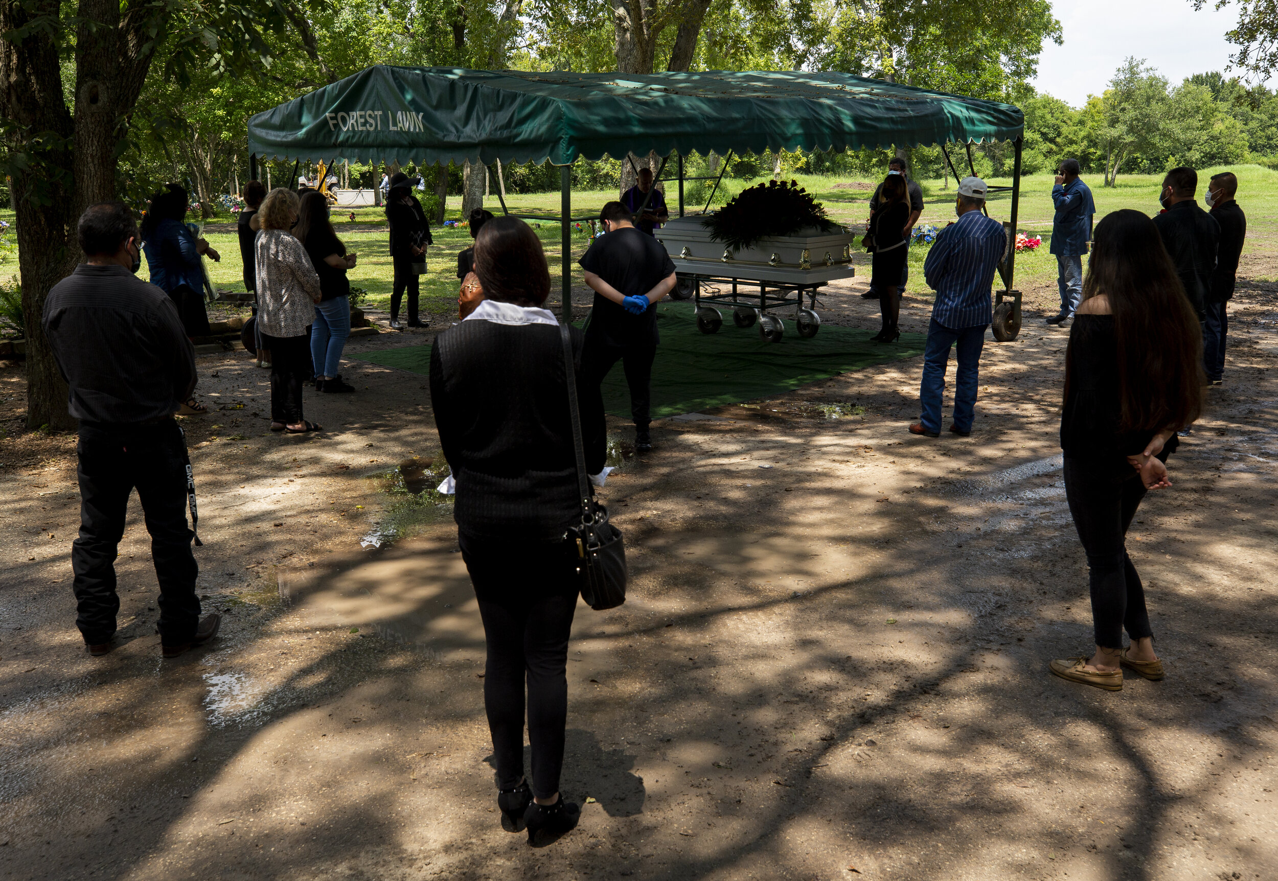  Family stand socially distant while attending the funeral of Trancito Rangel, 46, a construction worker who died of COVID-19, at Forest Lawn Cemetery on Tuesday, Aug. 4, 2020, in Houston. 