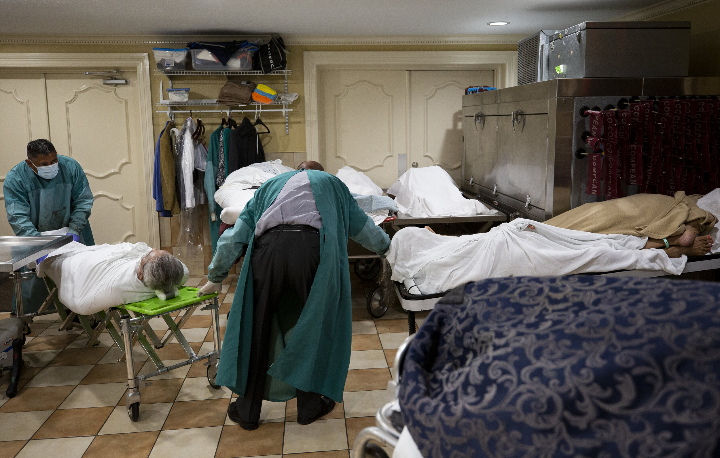  Mortician Jeff Sonka, center, and his assistant Manuel Santos, left, rearrange the deceased bodies that have been already embalmed inside the mortuary room at Compean Funeral Home on Tuesday, Aug. 4, 2020, in Houston. The funeral home, which serves 