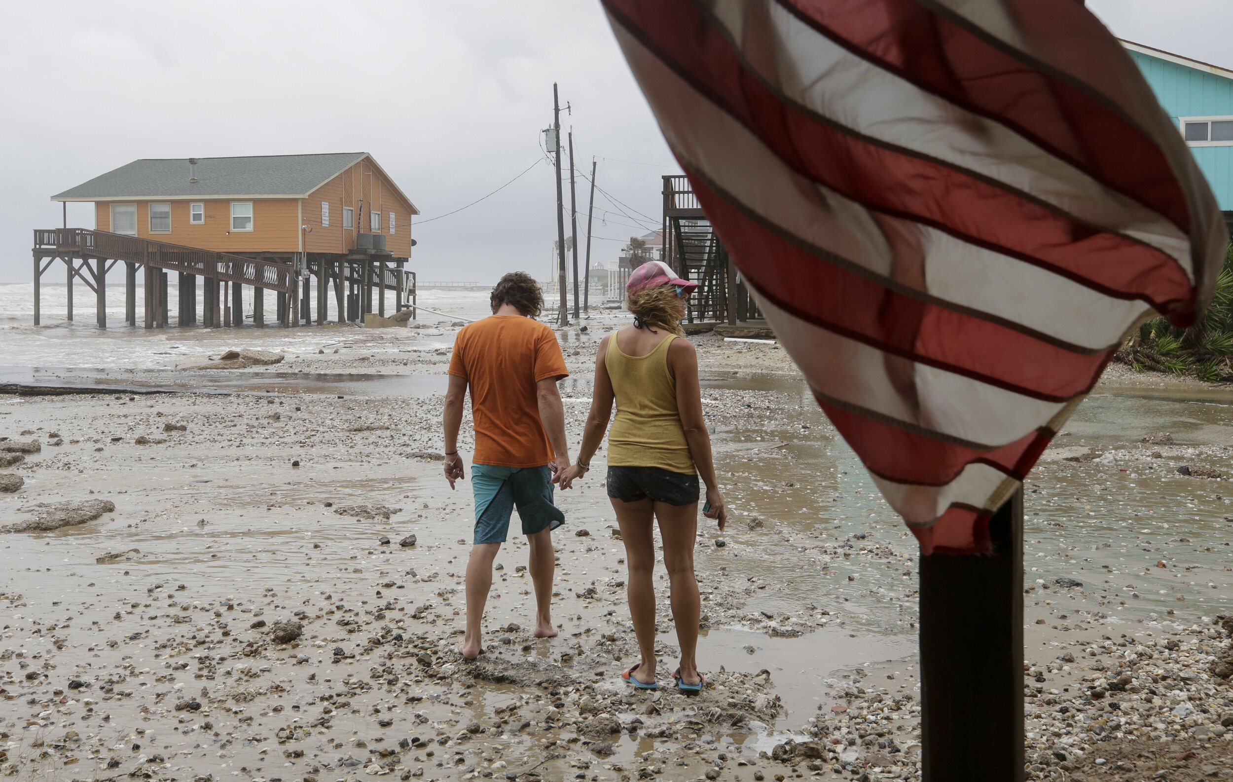  Adam Maubach, left, and Jo Dove, center, look at the erosion caused by Tropical Storm Beta on Monday, Sept. 21, 2020, in Surfside Beach, Texas. The couple said before the storm there used to be sand dunes where Thunder Road, pictured left, ended. 