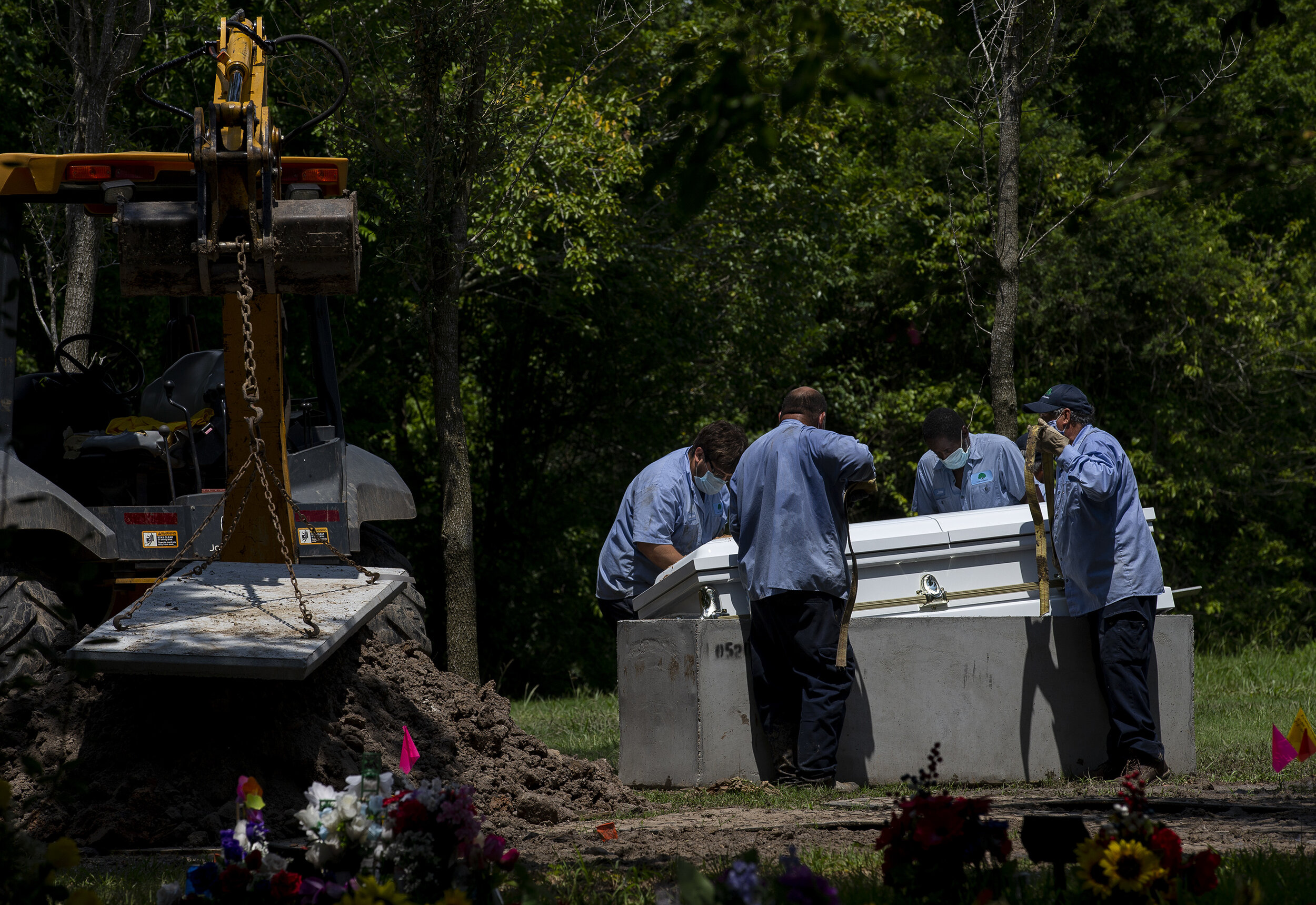  Forest Lawn Cemetery workers lower Trancito Rangel's casket during funeral services at Forest Lawn Cemetery on Tuesday, Aug. 4, 2020, in Houston. Rangel, 46, was a construction worker who died of COVID-19. 