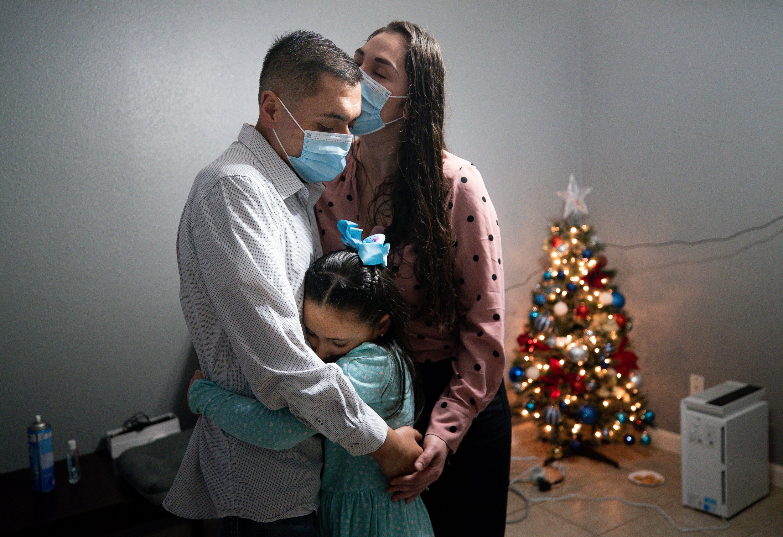  Jesus hugs Perla and his daughter, Victoria, in their living room during Christmas Eve on Friday, Dec. 24, 2021, in Baytown, Texas. 