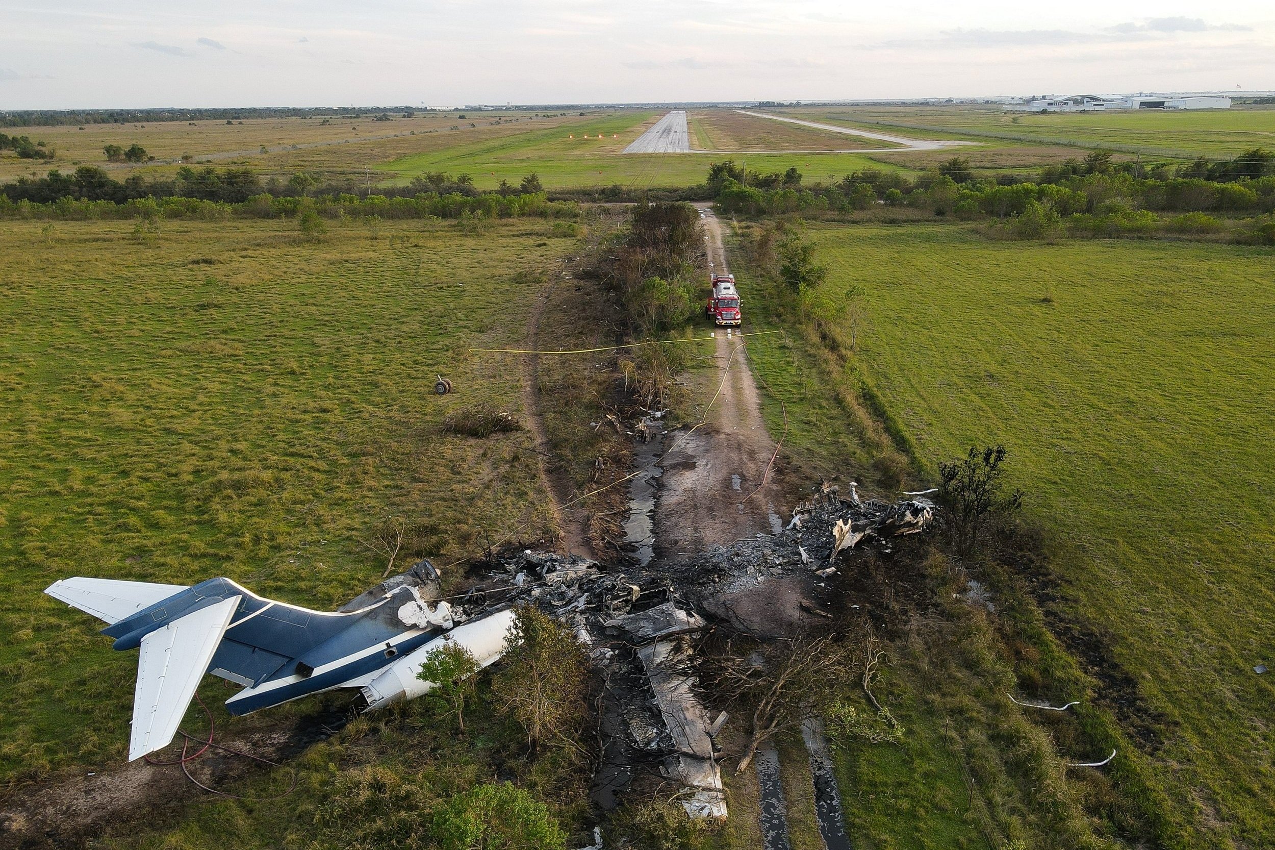  The remnants of an aircraft, which caught fire soon after a failed take-off attempt at Houston Executive Airport, can be seen just north of Morton Road on Tuesday, Oct. 19, 2021, in Brookshire, Texas. 