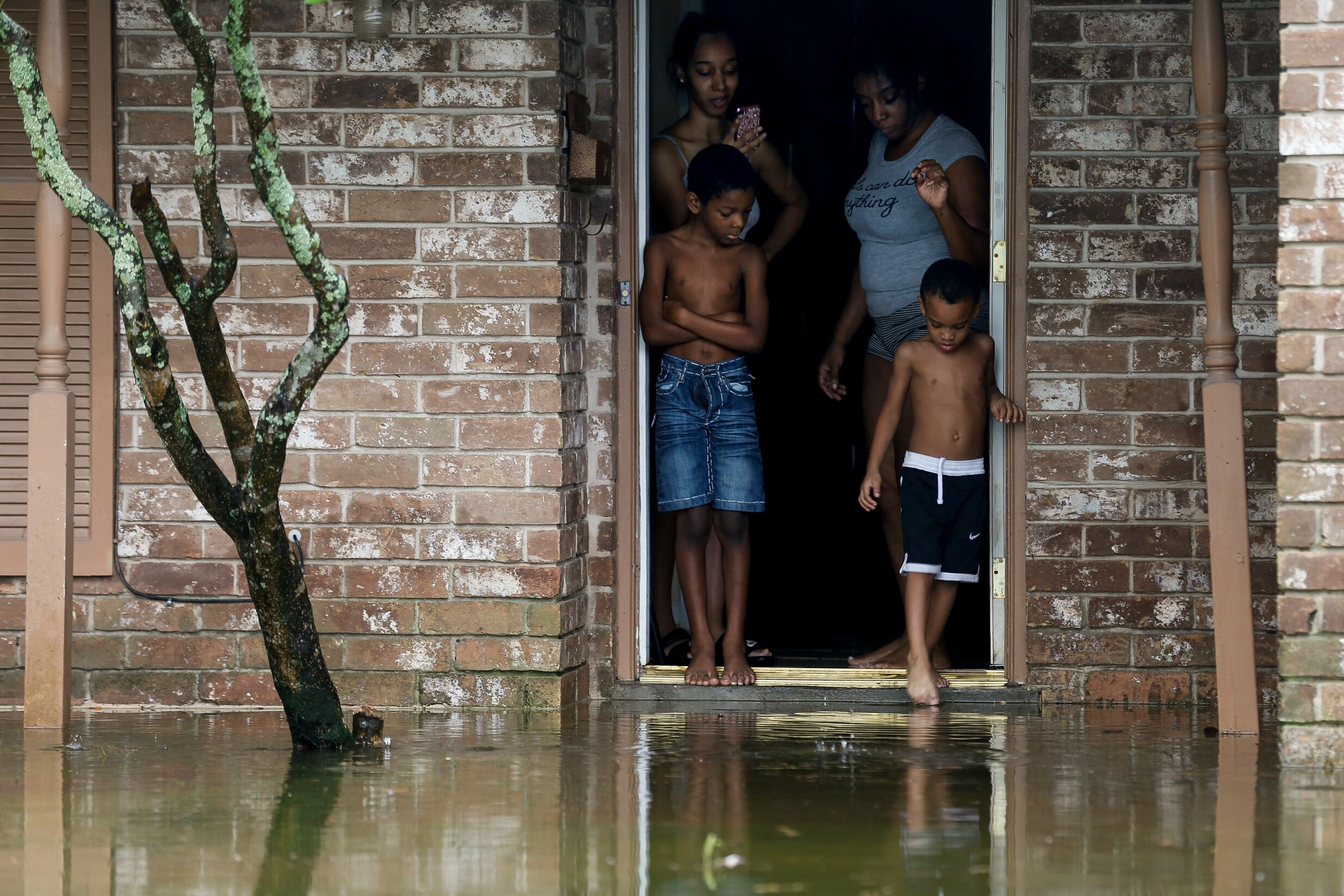  Eight-year-old Cam'ron Maltie, left, and Adrian Murray, 4, look at the their flooded front lawn during Tropical Storm Beta on Tuesday, Sept. 22, 2020, in Houston, Texas. Their family has been living in the home for a year, and didn't know the neighb