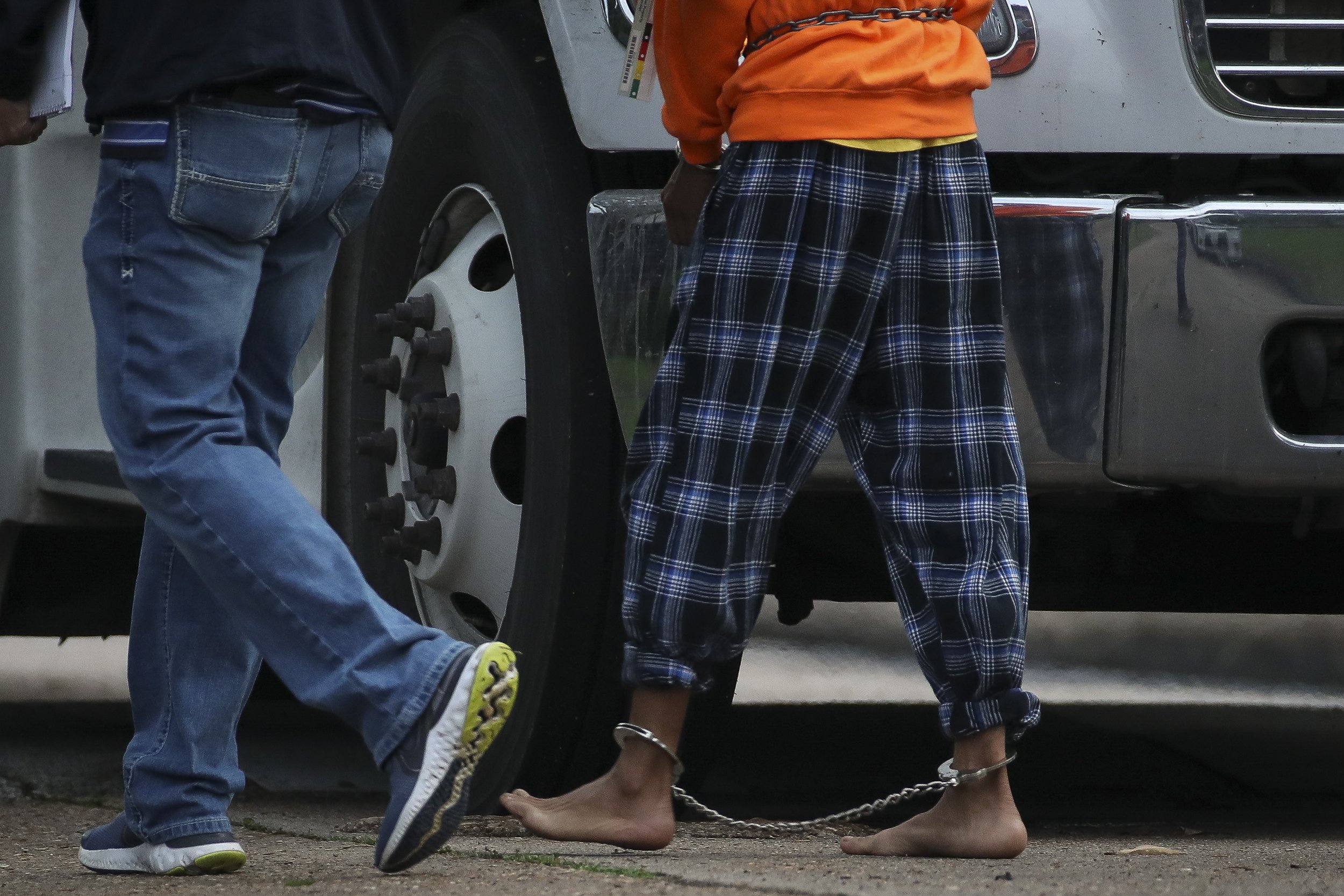  An undocumented migrant is ushered into a bus from the scene of a human smuggling case, where more than 90 undocumented migrants were found inside a home on the 12200 block of Chessington Drive, on Friday, April 30, 2021, in Houston, Texas. A Housto