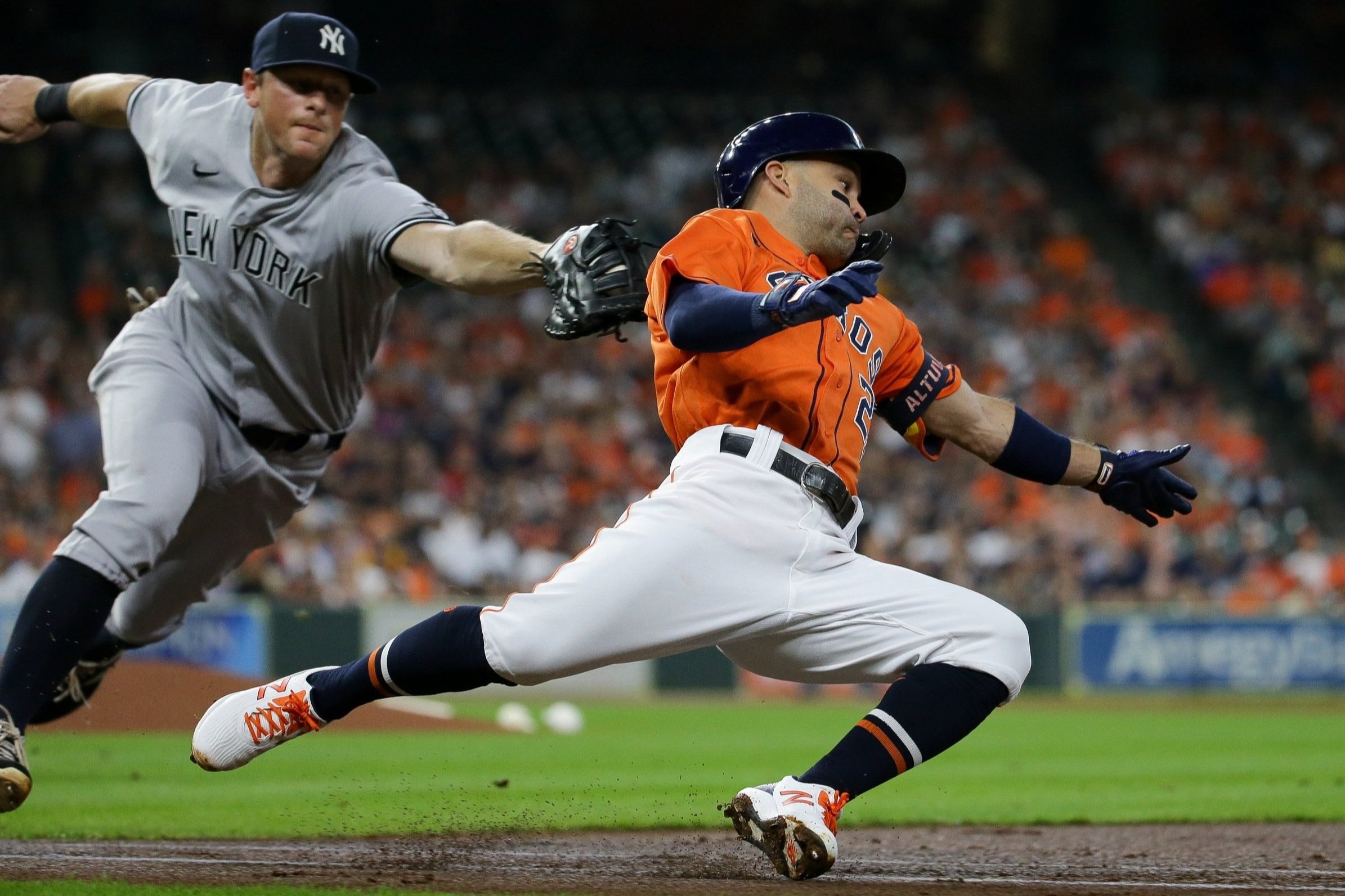  Houston Astros second baseman Jose Altuve (27) unsuccessfully tries to avoid the tag by New York Yankees first baseman DJ LeMahieu (26) during the first inning of an MLB game at Minute Maid Park on Friday, July 9, 2021, in Houston.  