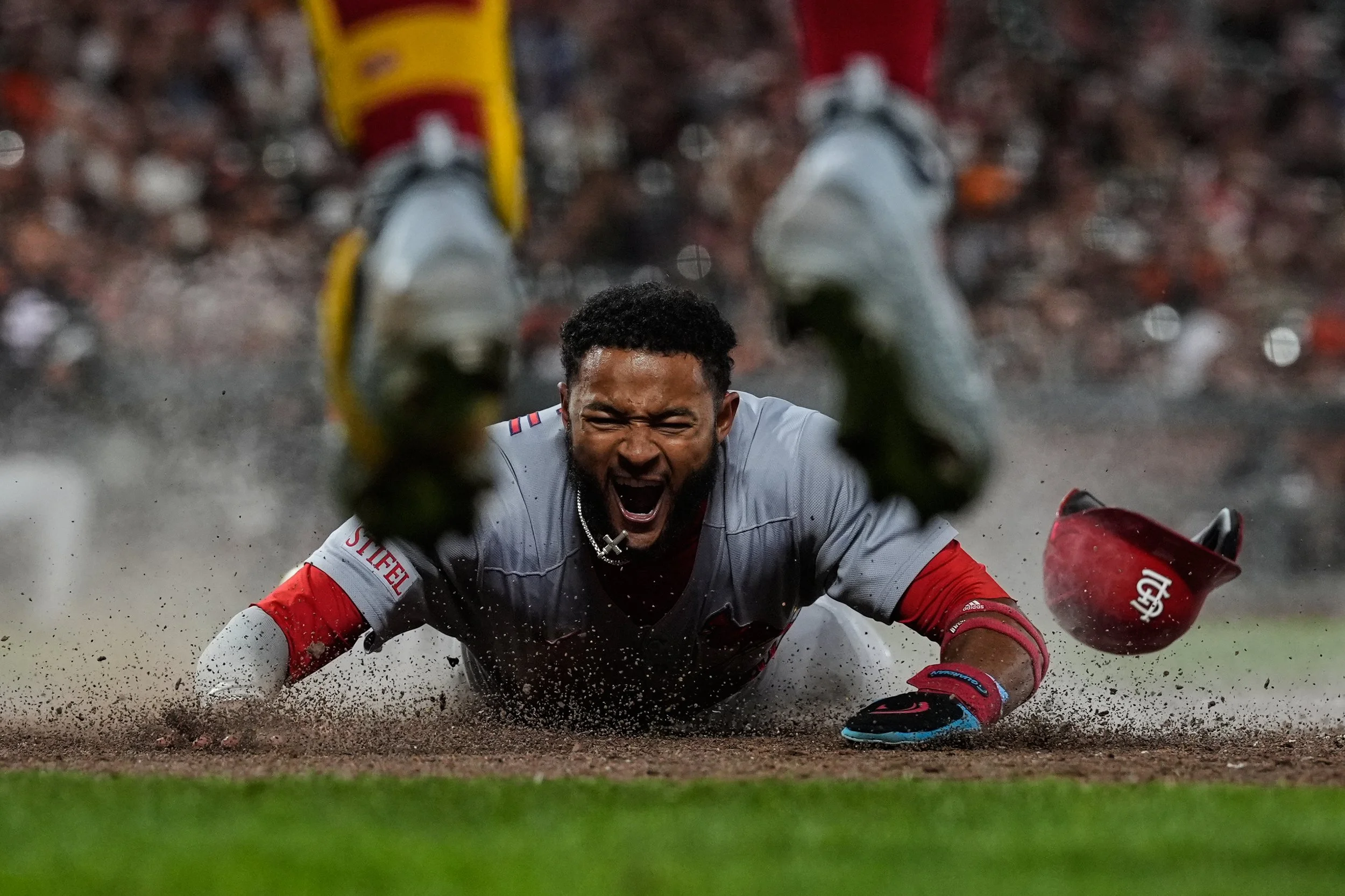 St. Louis Cardinals’ Victor Scott II, bottom, scores against the San Francisco Giants on Brendan Donovan’s double during the ninth inning of a baseball game, Tuesday, Sept. 23, 2025, in San Francisco. (AP Photo/Godofredo A. Vásquez)