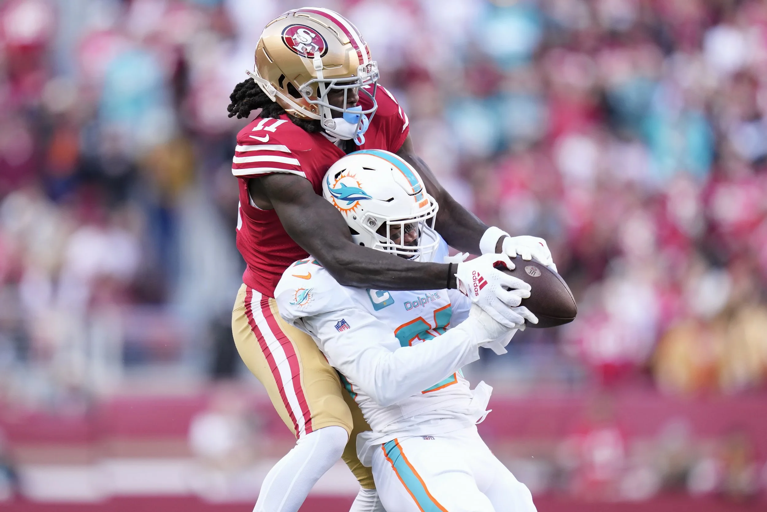 Miami Dolphins cornerback Xavien Howard, bottom, intercepts a pass in front of San Francisco 49ers wide receiver Brandon Aiyuk during the first half of an NFL football game in Santa Clara, Calif., Sunday, Dec. 4, 2022. (AP Photo/Godofredo A. Vásquez