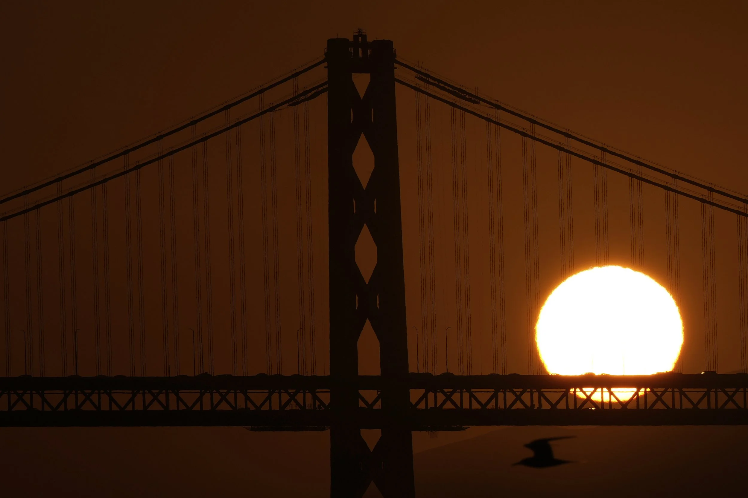  The sun sets behind the Bay Bridge, Saturday, April 12, 2025, in Oakland, Calif. (AP Photo/Godofredo A. Vásquez) 