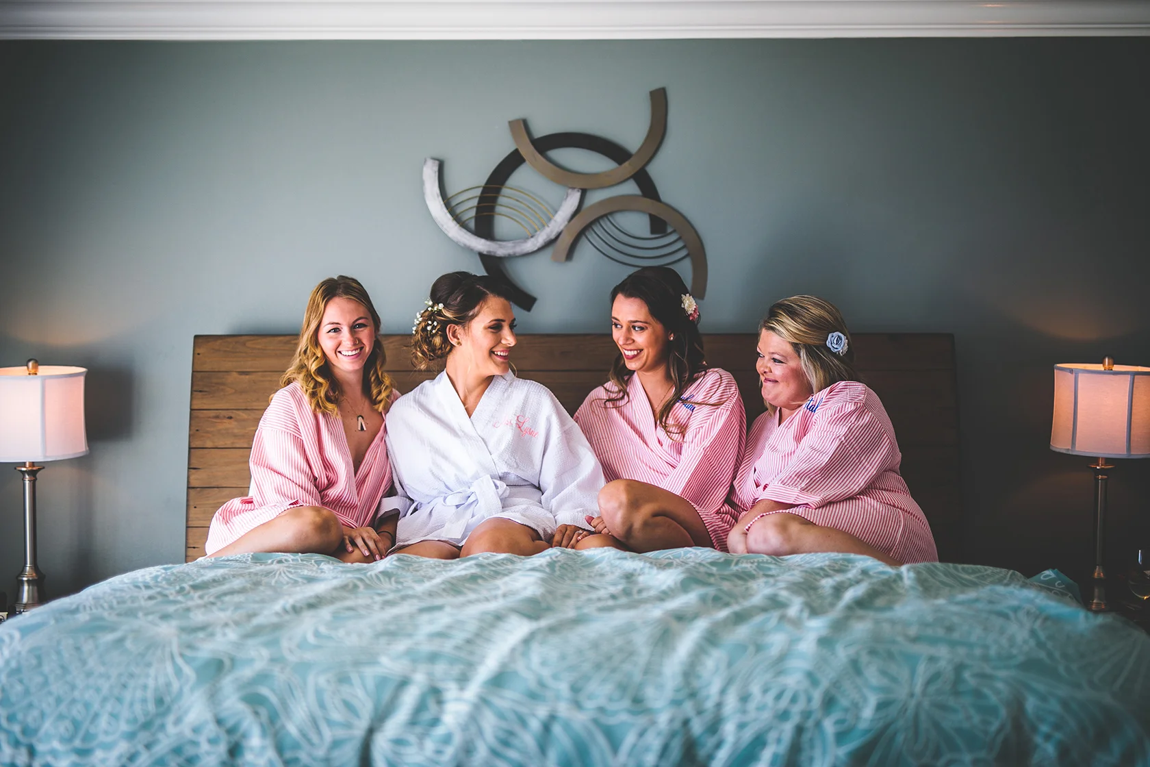 bridesmaids laughing on a bed.jpg