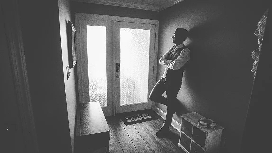 the groom standing in a hallway.jpg