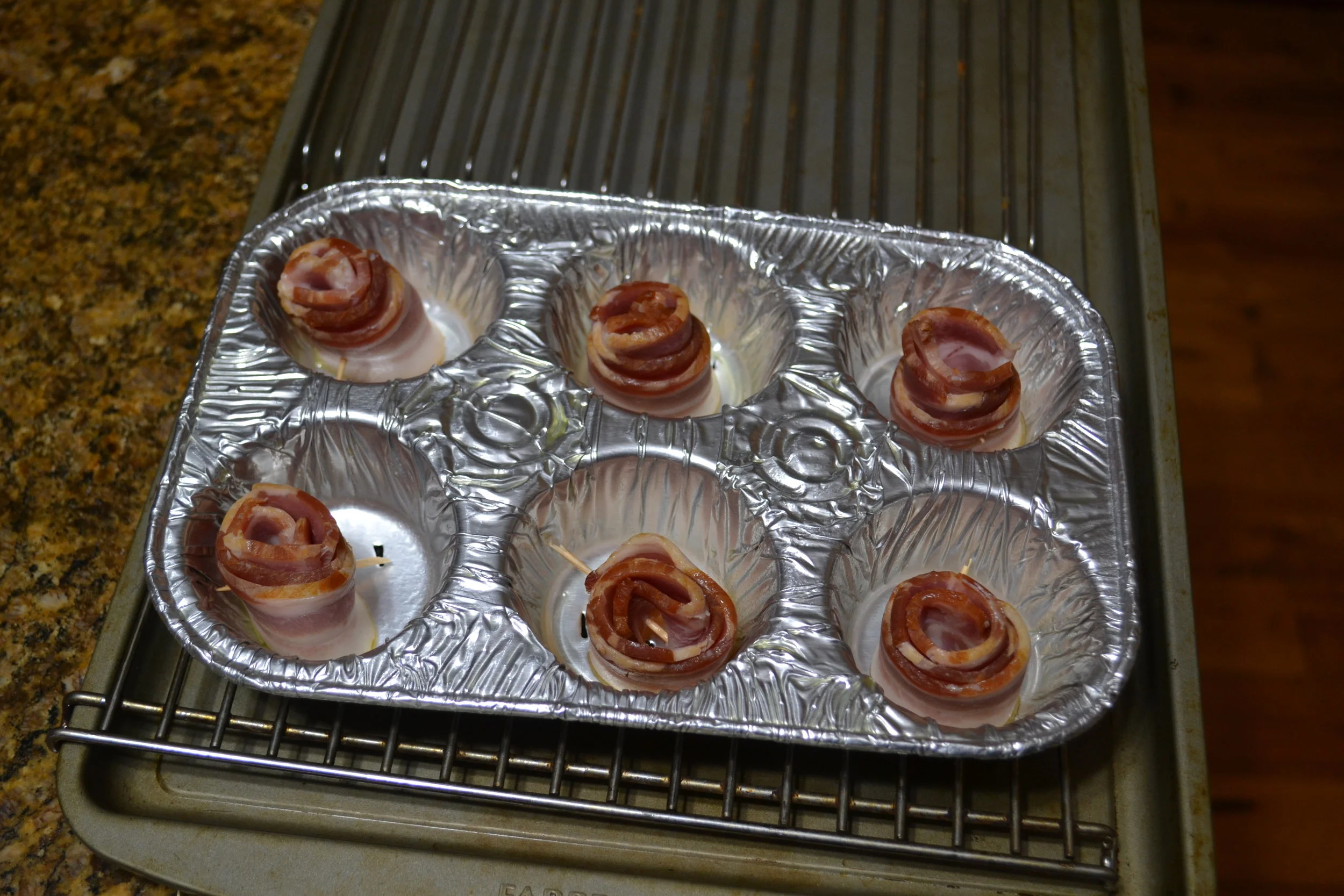 As you can see, I placed the aluminum pan on a rack that was placed on a cookie sheet. This will allow the grease to drain away. Next, place in a 350²F oven for 15 - 20 minutes. You want them as crispy as you normally like your bacon. Remove from oven and place in your refrigerator for approximately 2 hours or until completely chilled. While your roses are chilling you can start to melt you chocolate. For these 6 roses I melted approximately 8 - 10 ounces of chocolate. I used Wilton Candy Melts. You will only need approximately 15 minutes to melt your chocolate. Remove your rose from refrigerator and remove the toothpick. Dip each rose into the chocolate and place on a plate so that you can place your chocolate covered bacon back into the refrigerator for just a few minutes. After they have chilled, stick onto the stem that you removed the artificial rose from earlier. And there you have some chocolate covered roses. Sweet and salty for your significant other. Great for Valentine's Day or any special occasion. 