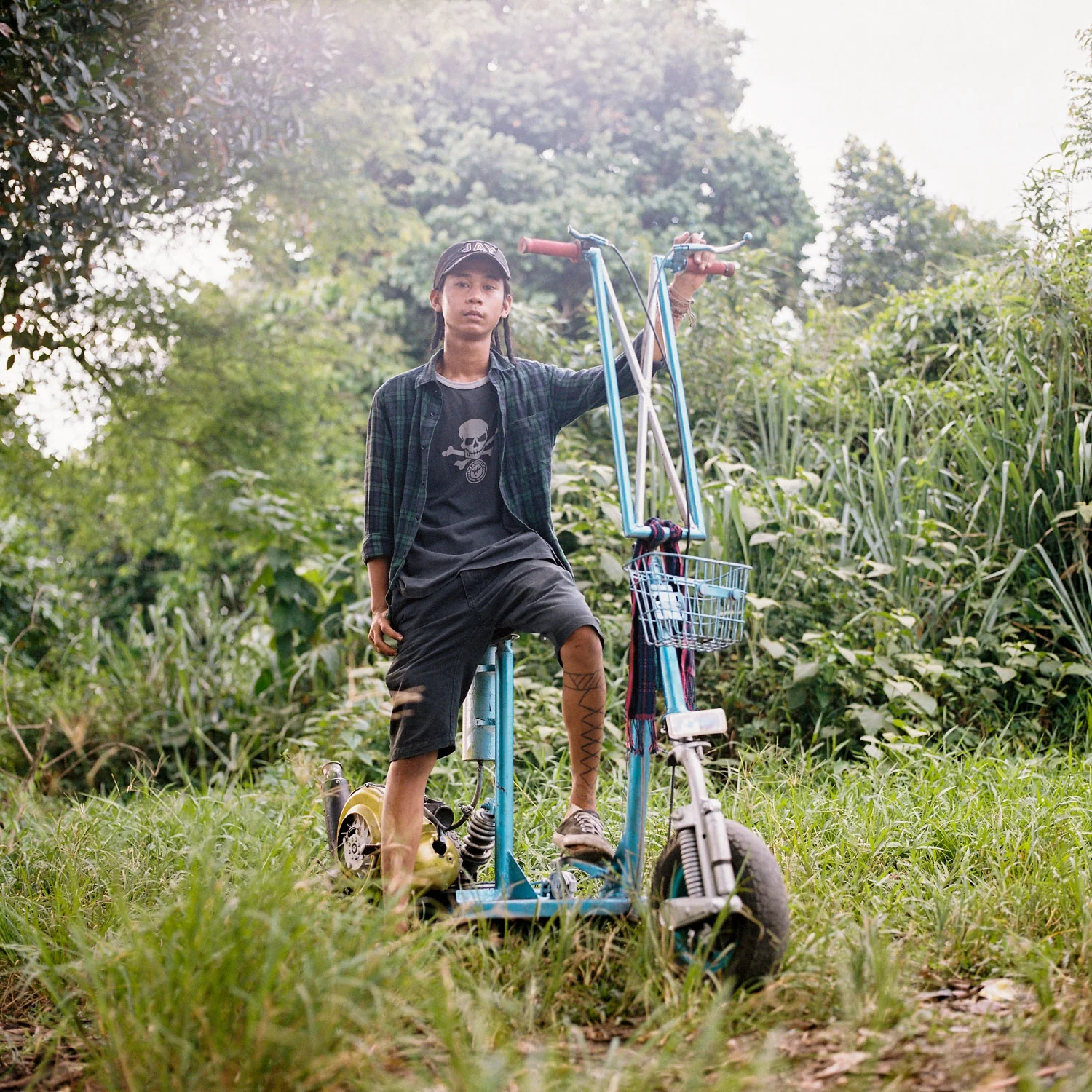 Bonjay, a scooterist from Jakarta, posed for a portrait with his kick scooter style vespa.