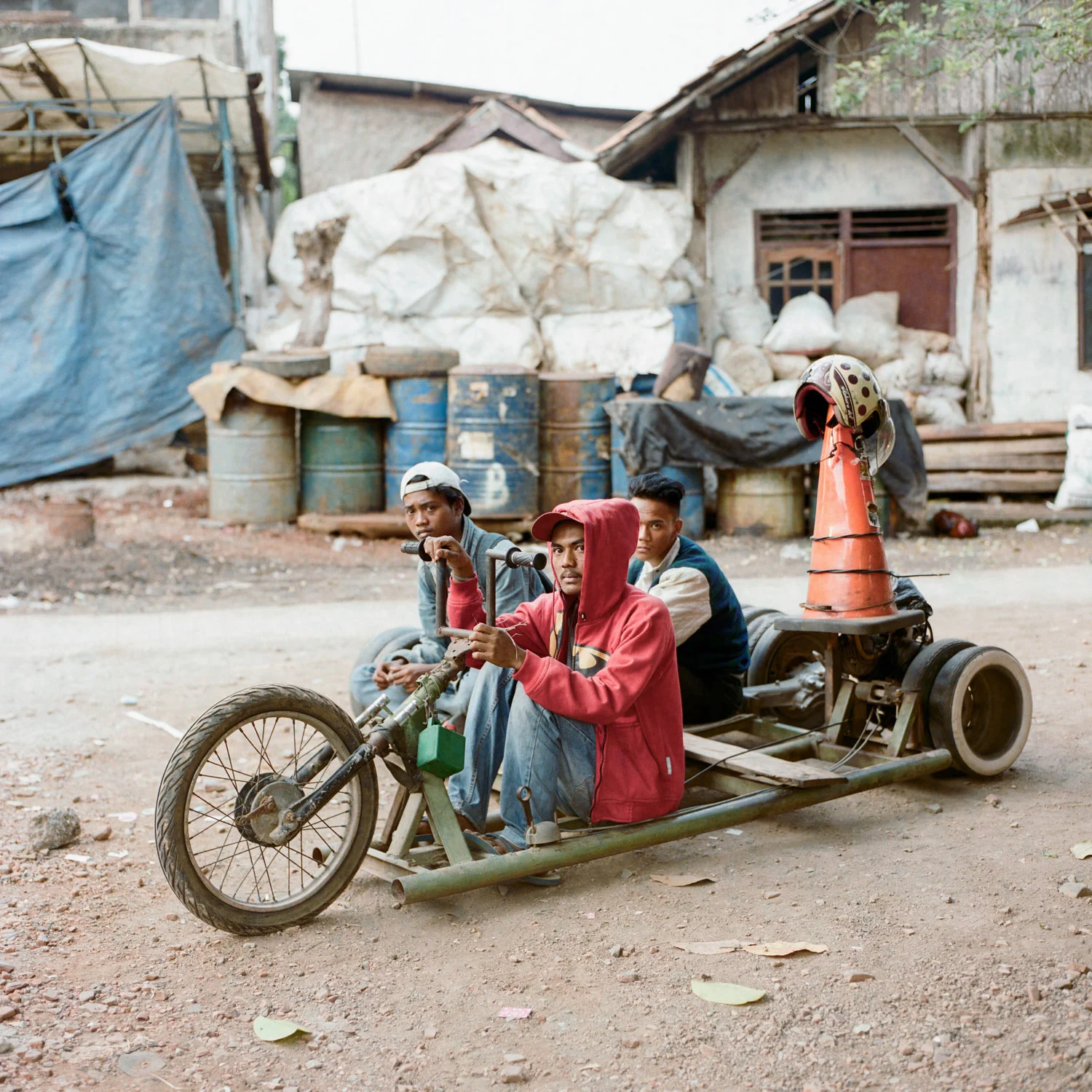 Three scooterists, Adul (middle), Bango (left), and Ajis (right), posed for a portrait with their custom-made lowrider vespa in Bekasi, a sprawling Jakarta suburb.