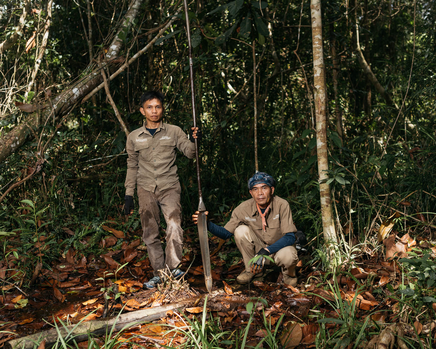  Portrait of Radius (left) and Hendri Saleh (right), staffs of PT Rimba Makmur Utama, after measuring the depth of peat in the forest. 