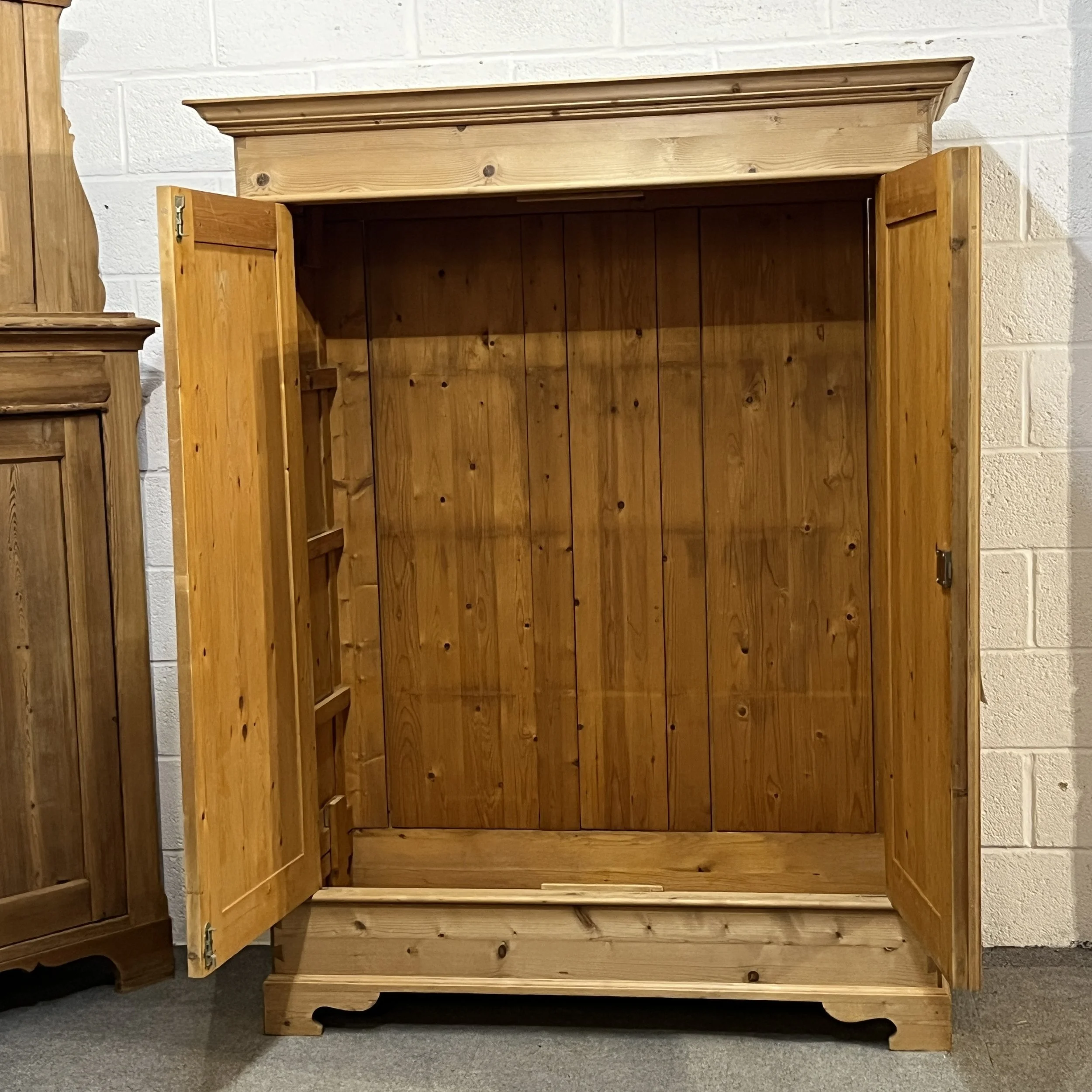 Double pine wardrobe with both doors open to show its wooden interior