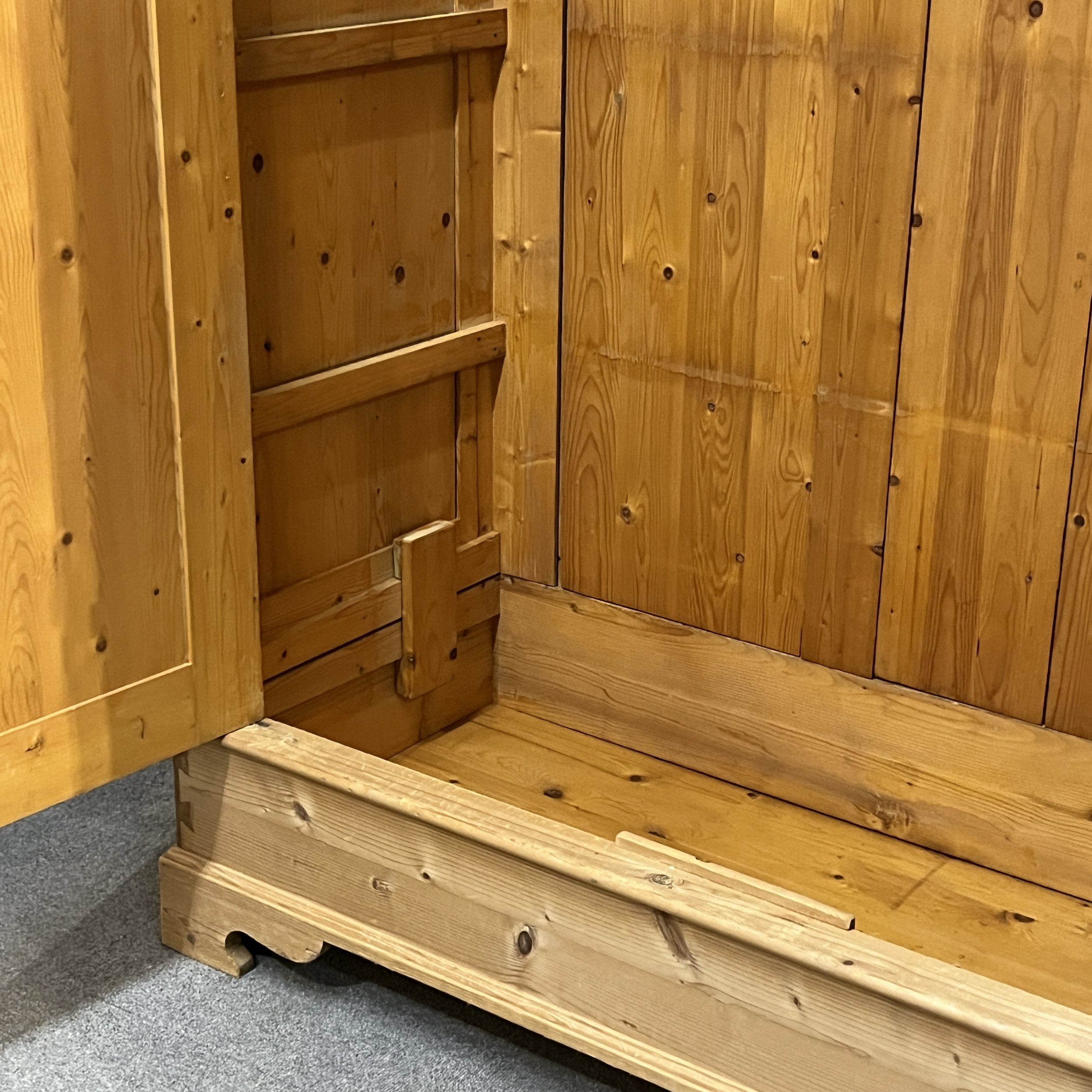 Close view of the pine wardrobe lower interior and open door