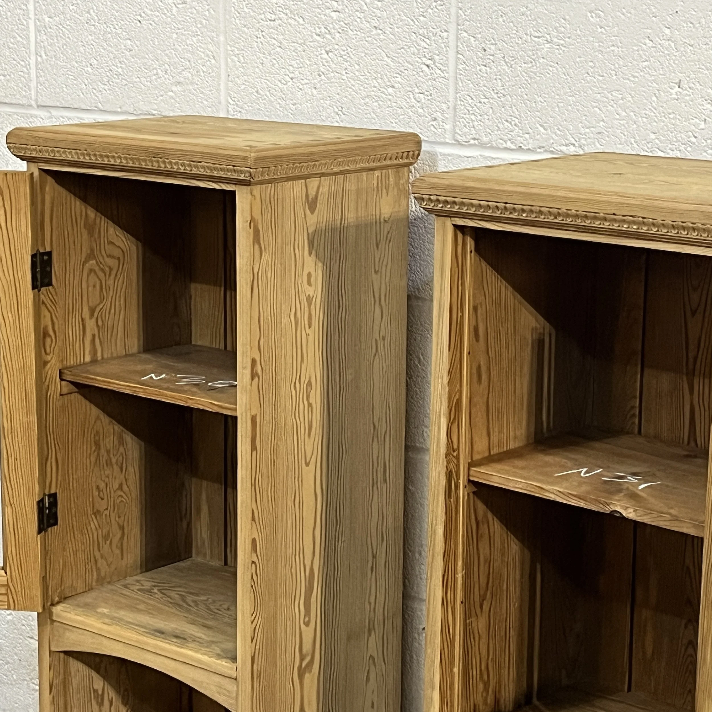Close-up of the open shelves and lower compartment of a slender pine glazed cabinet