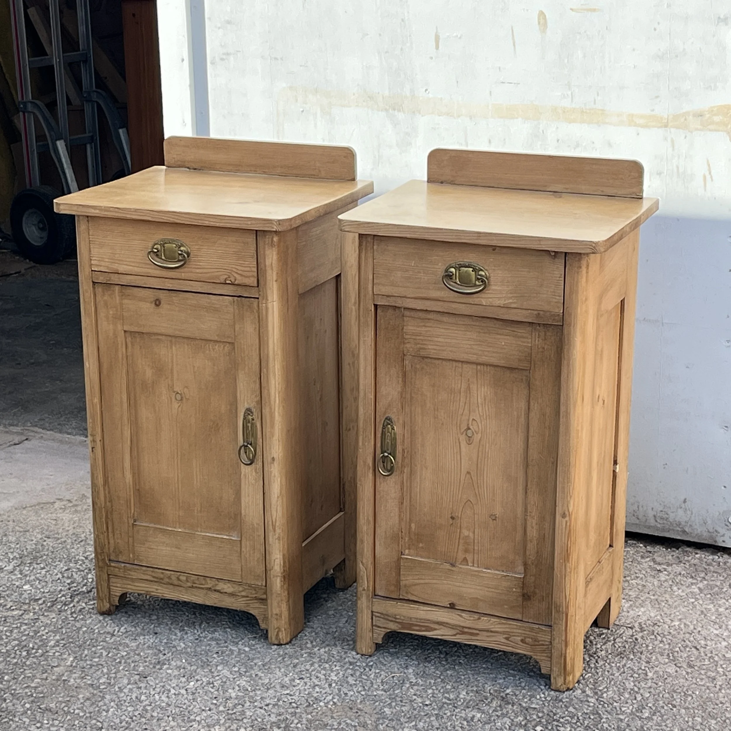 Pair of pine bedside cupboards with single drawers, panelled doors and small raised backs