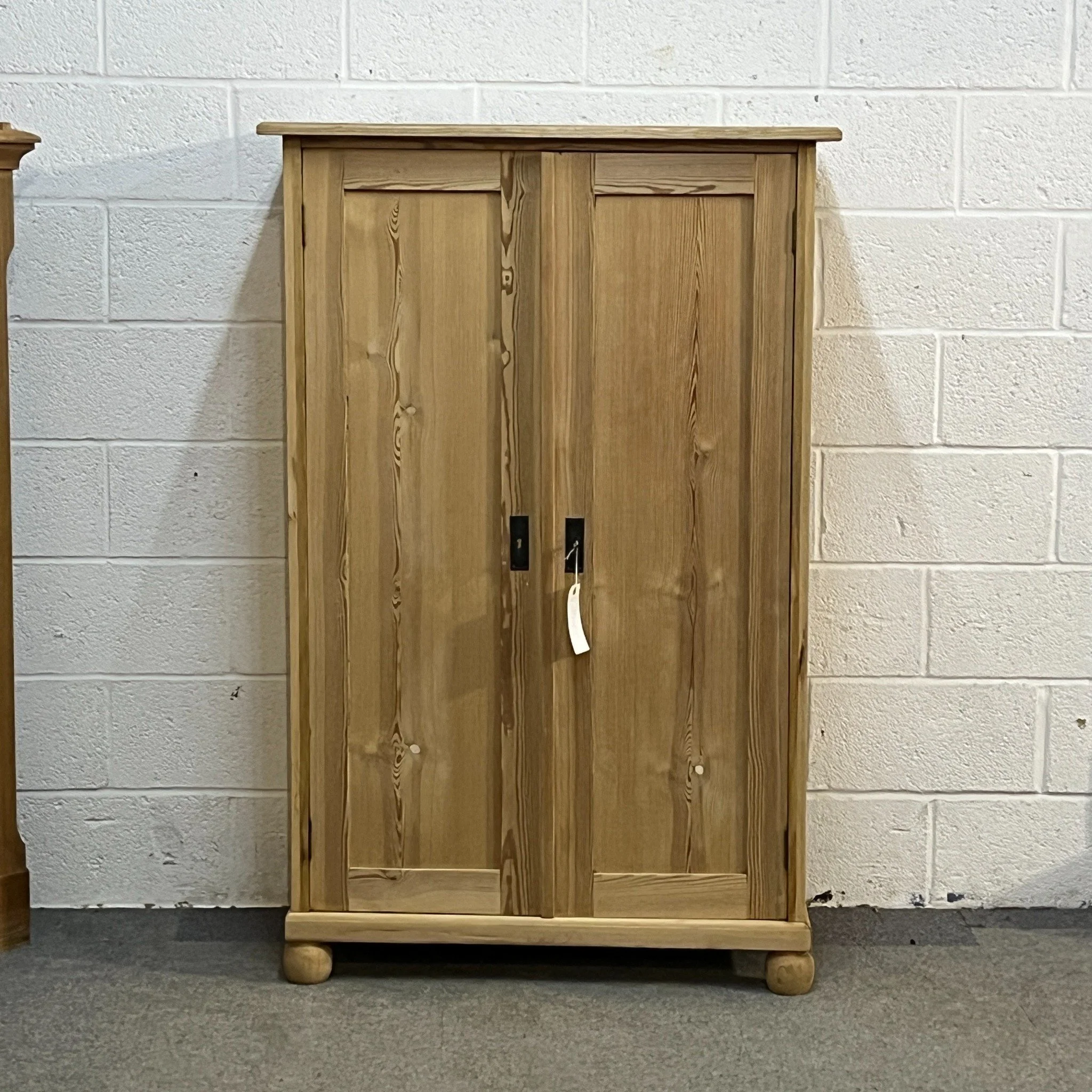 N7600D pine cupboard — closer straight front view showing key plates and natural grain