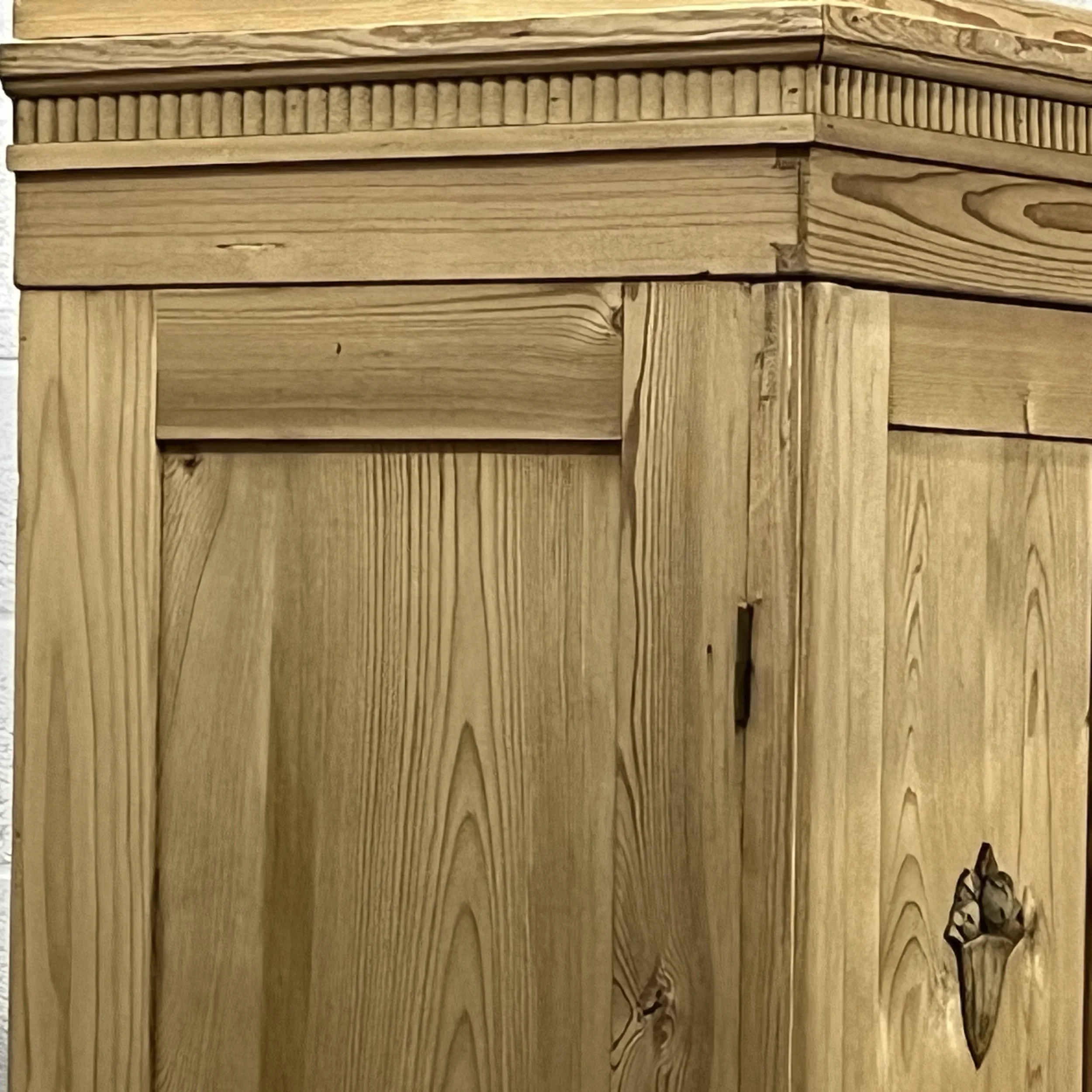 Detail of the pine wardrobe upper corner, panelled door and cornice