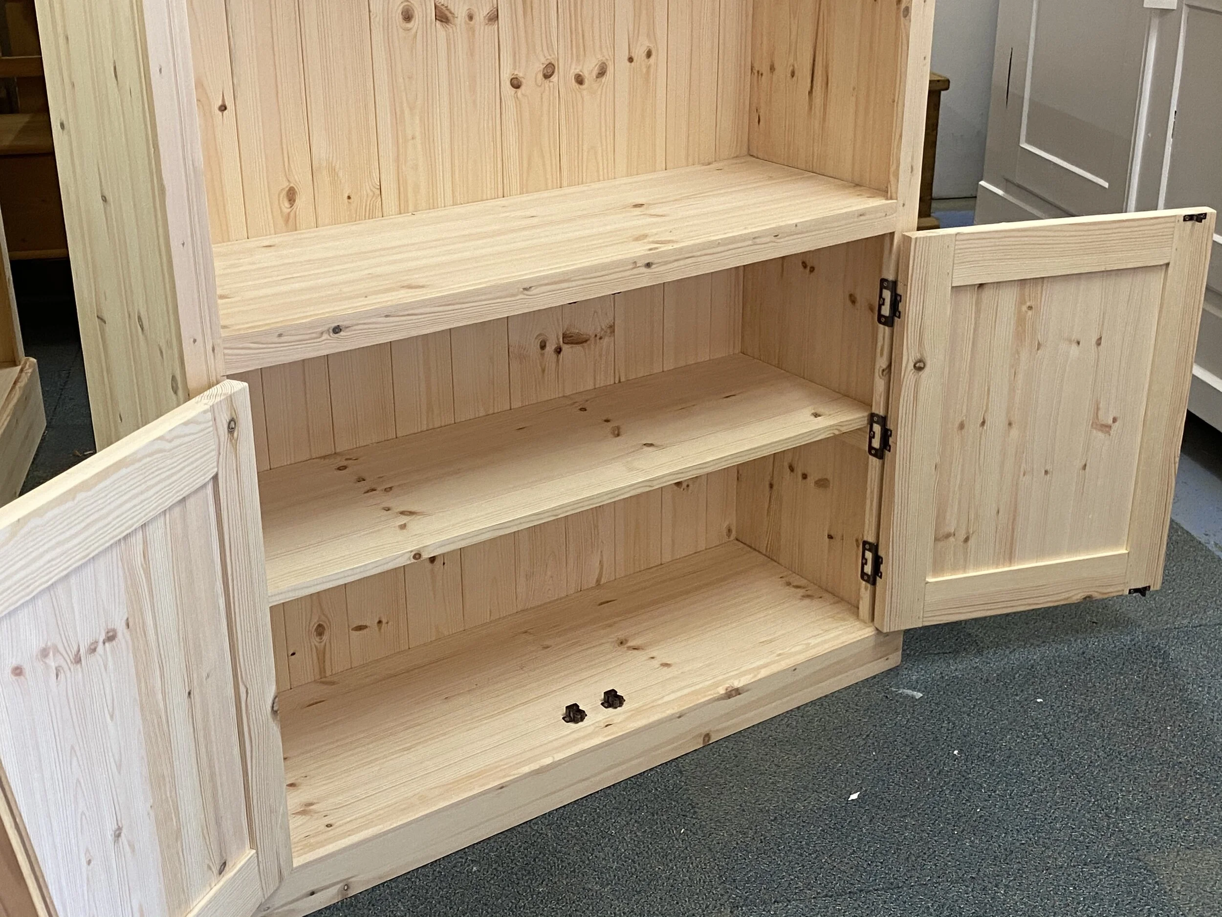 Pine bookcase with bottom cupboard doors in bare wood