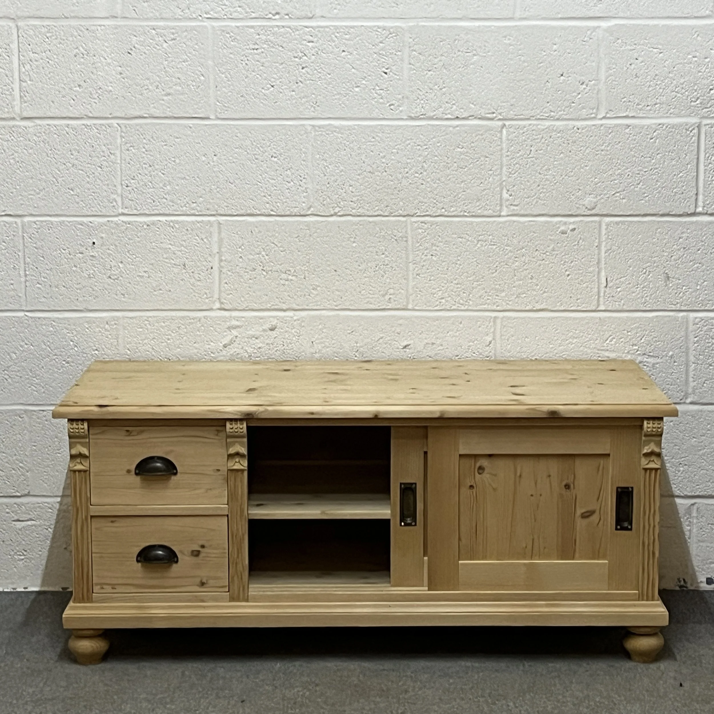 Low pine cupboard with 2 drawers and sliding doors
