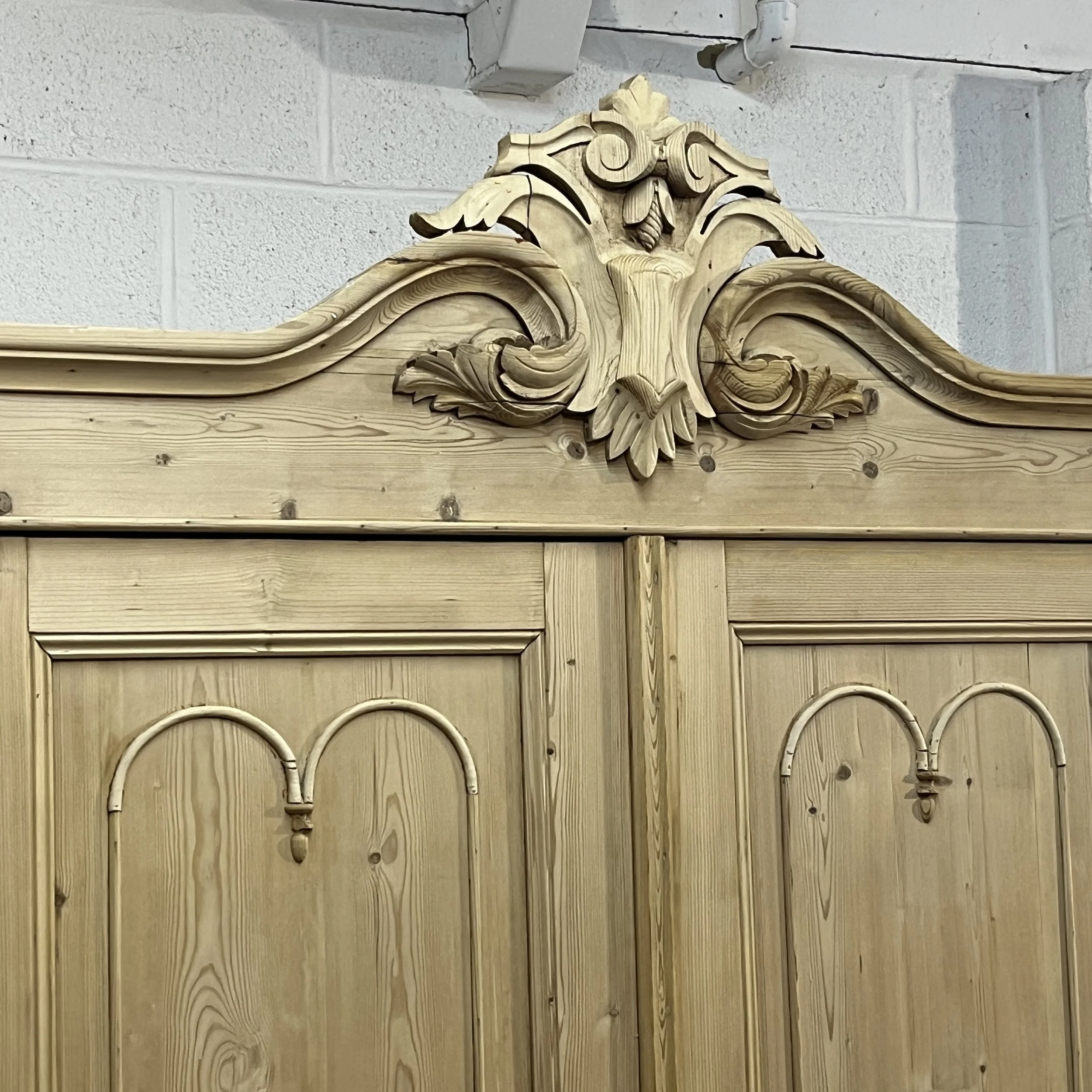 Close view of the pine wardrobe carved floral crest and shaped cornice
