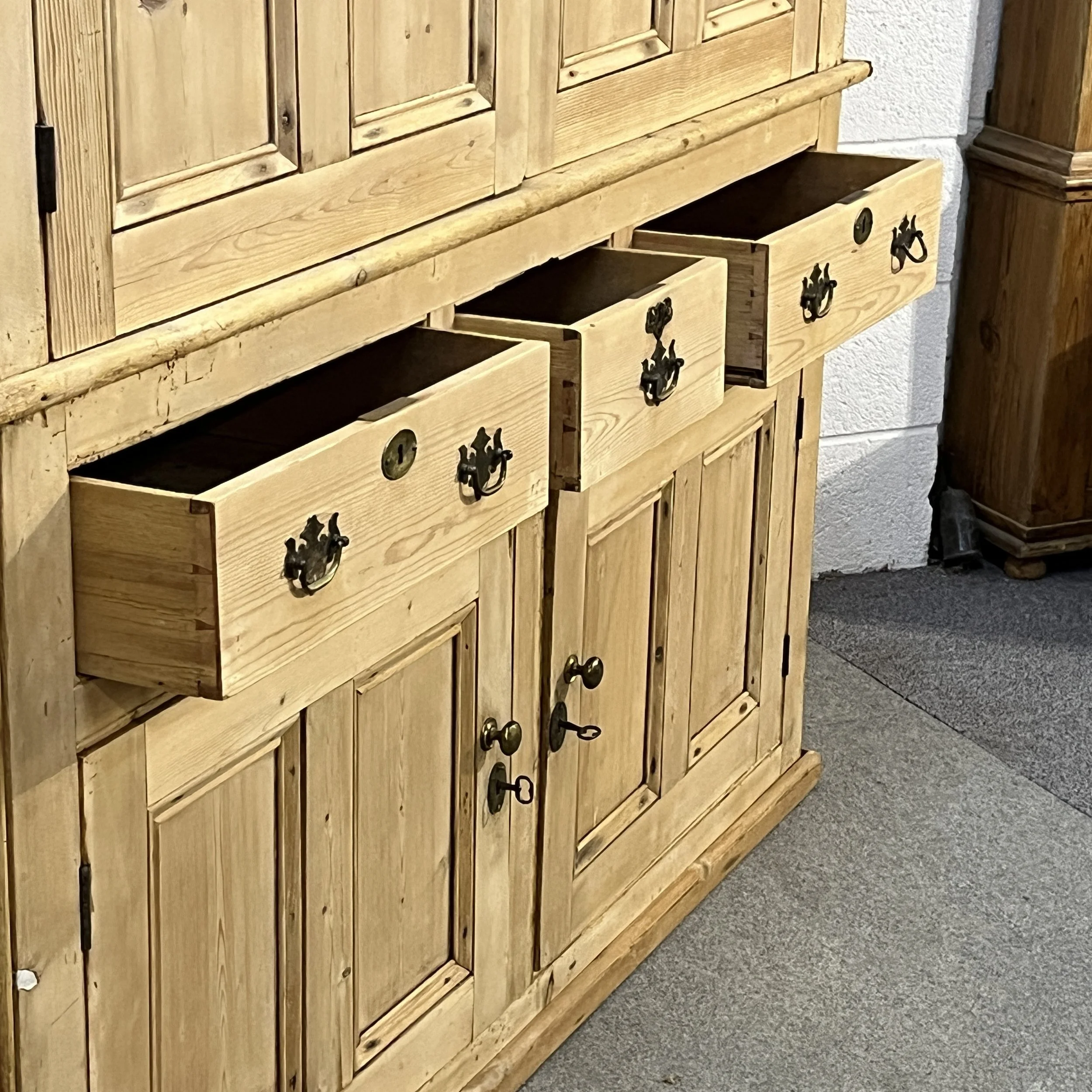 Three open drawers on pine cupboard N7700I showing dovetail joints and brass drop handles