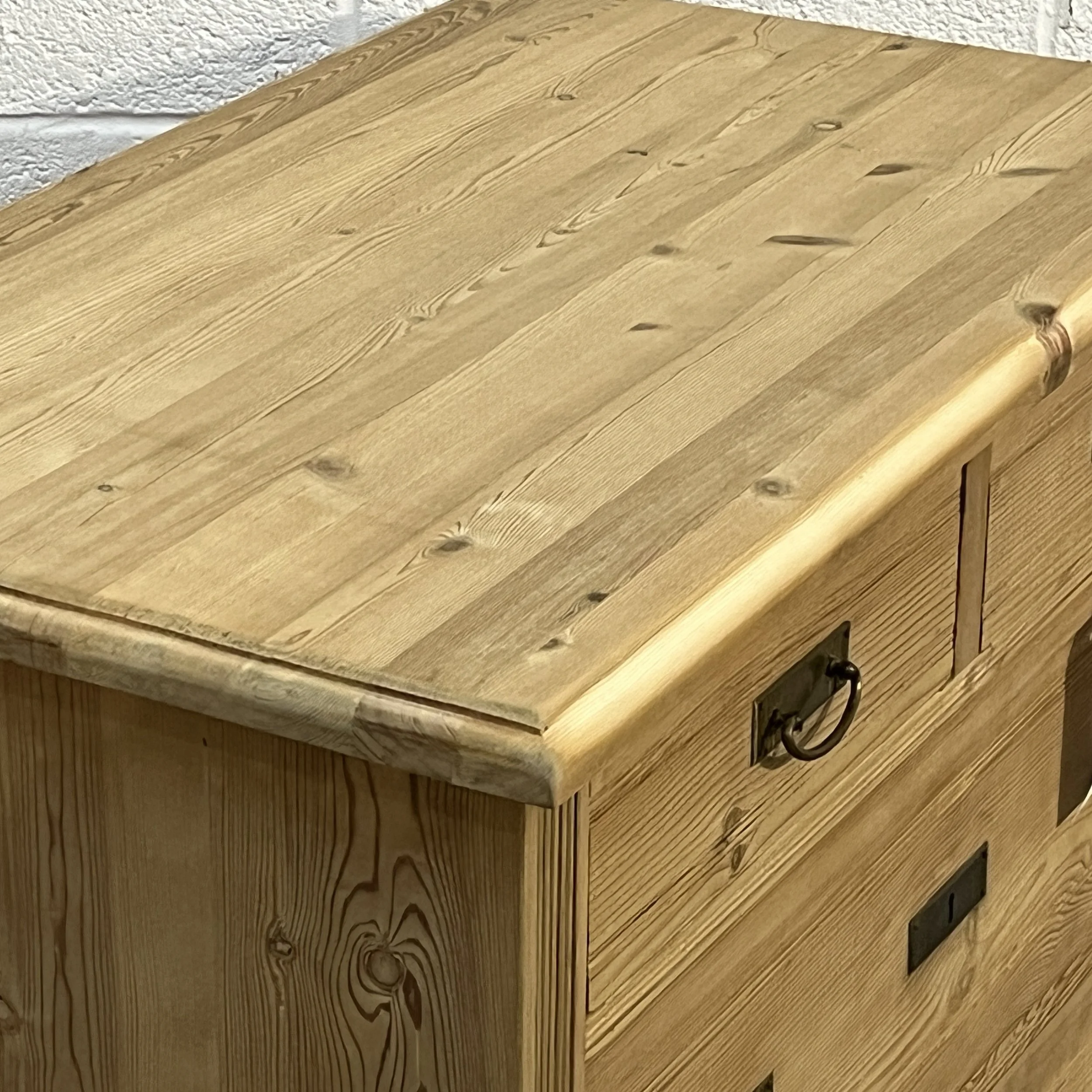 Close-up of the rounded pine top and wood grain on 1930s chest of drawers N8004C.