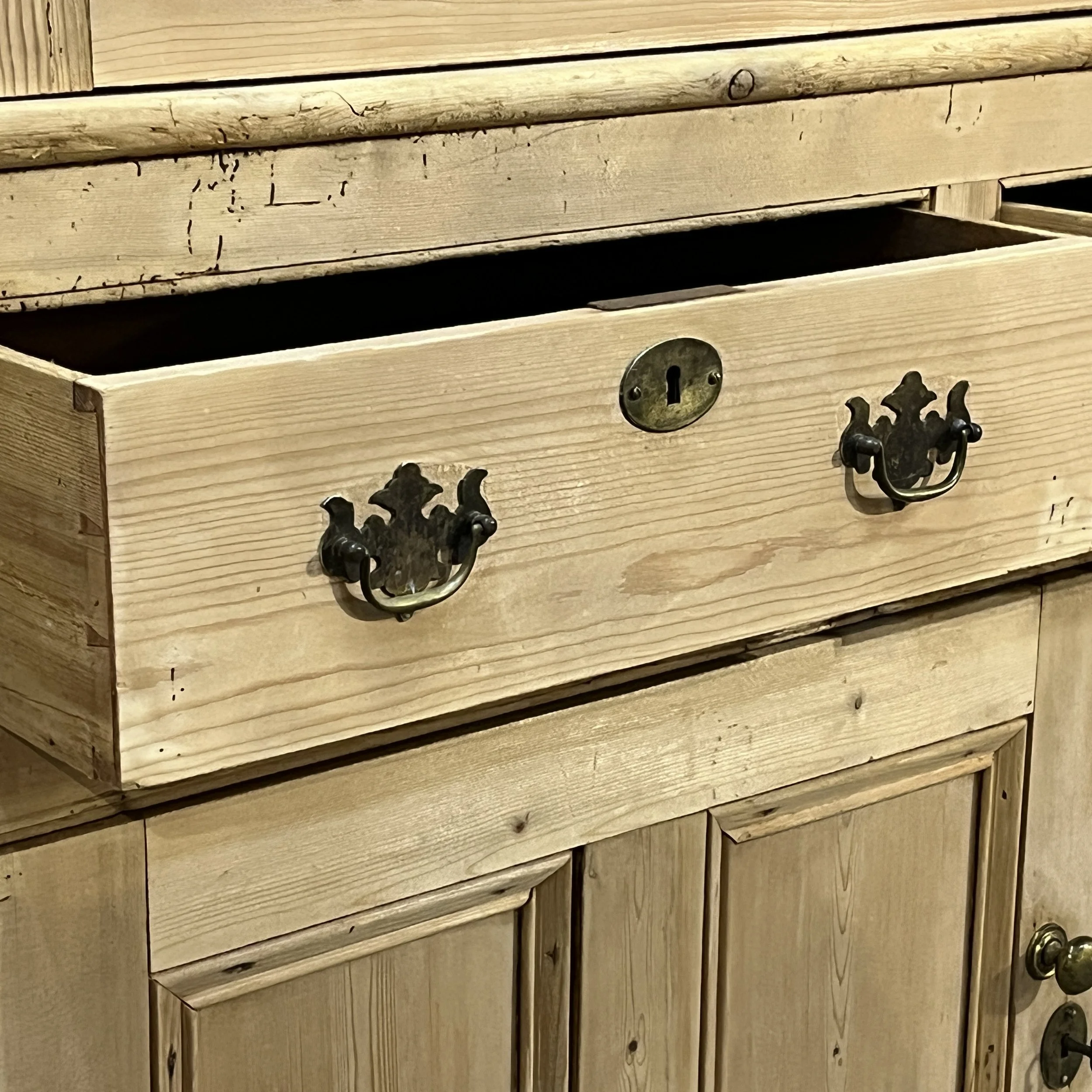 Close view of brass drawer handles, keyhole escutcheon and old wear on cupboard N7700I
