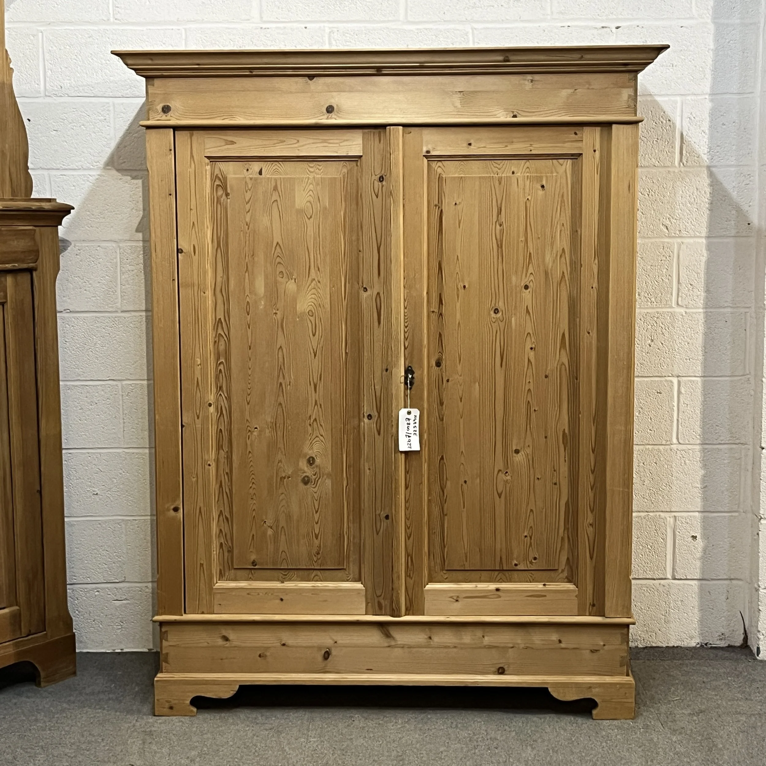 Front view of the double pine wardrobe with panelled doors and shaped plinth